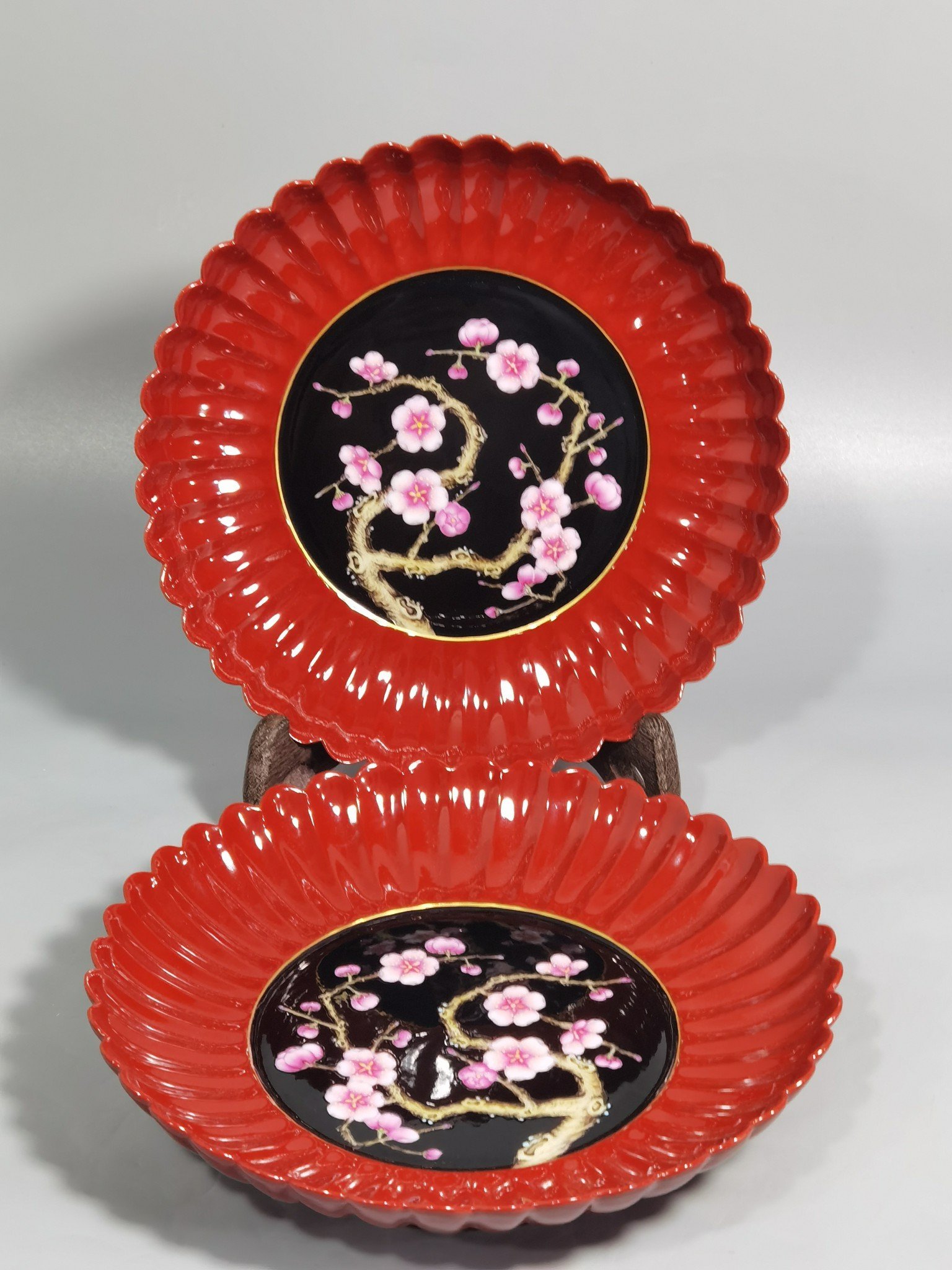 Qing Dynasty Qianlong coral red ground black ground pastel plum blossom melon petal plate