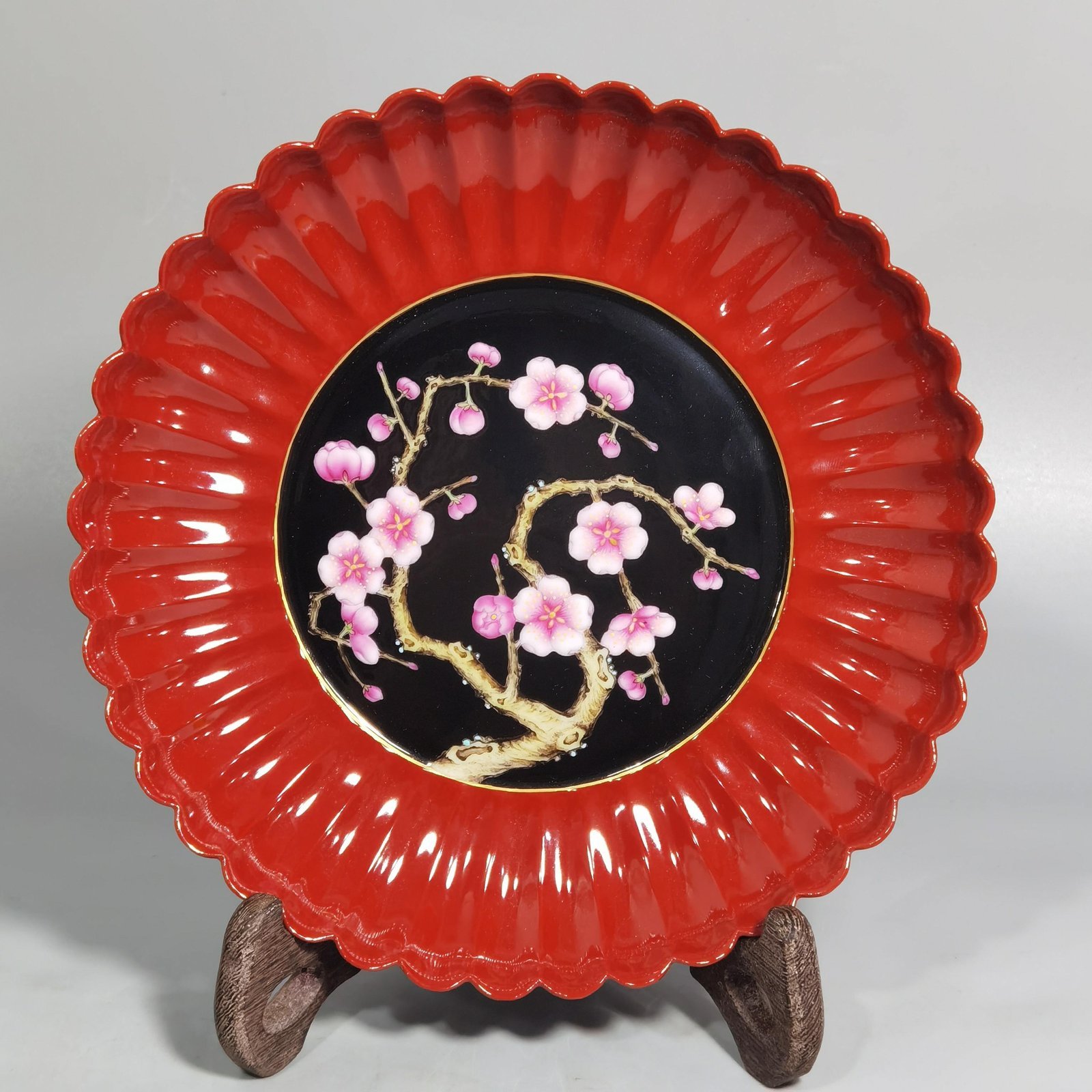 Qing Dynasty Qianlong coral red ground black ground pastel plum blossom melon petal plate