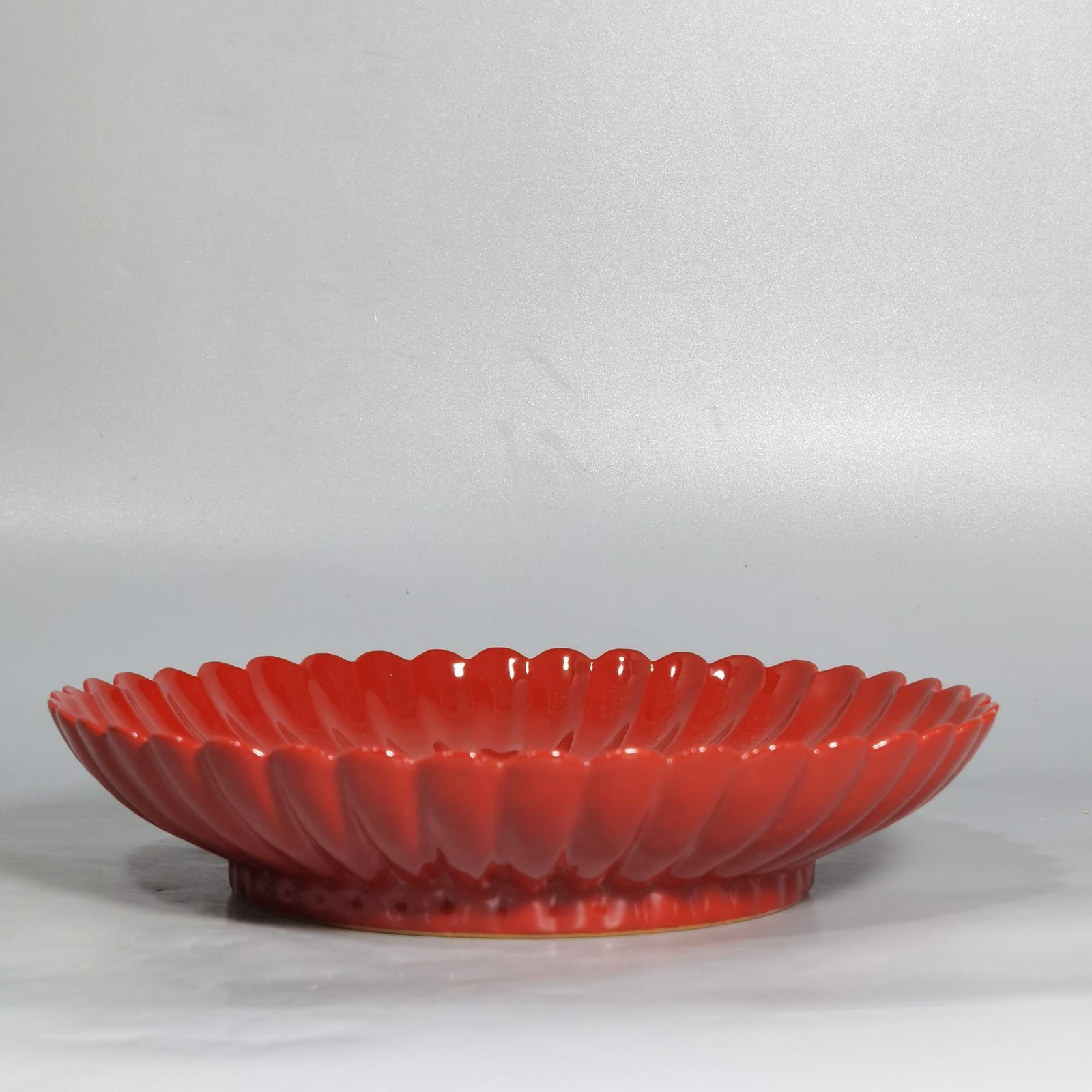 Qing Dynasty Qianlong coral red ground black ground pastel plum blossom melon petal plate