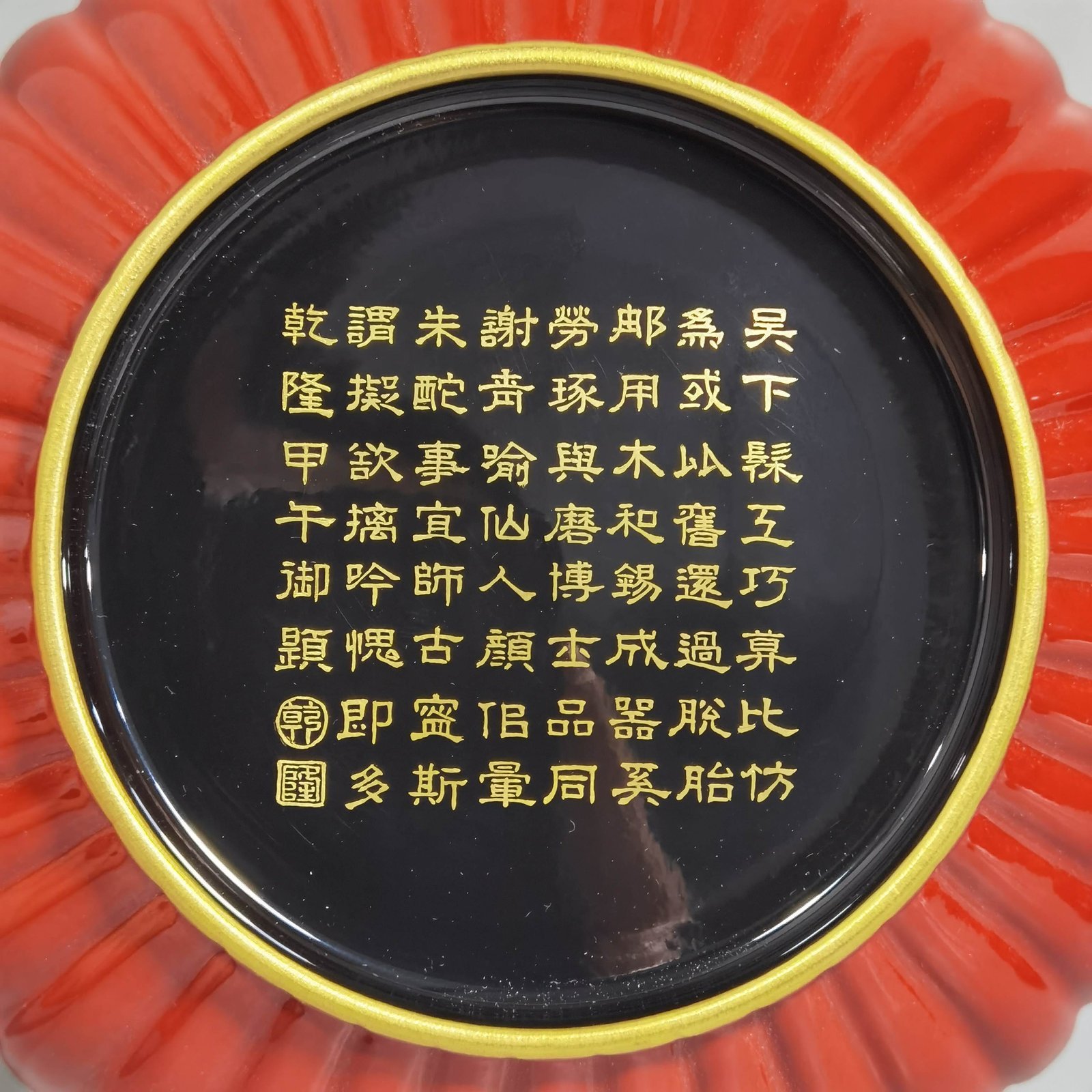 Qing Dynasty Qianlong coral red ground black ground pastel plum blossom melon petal plate