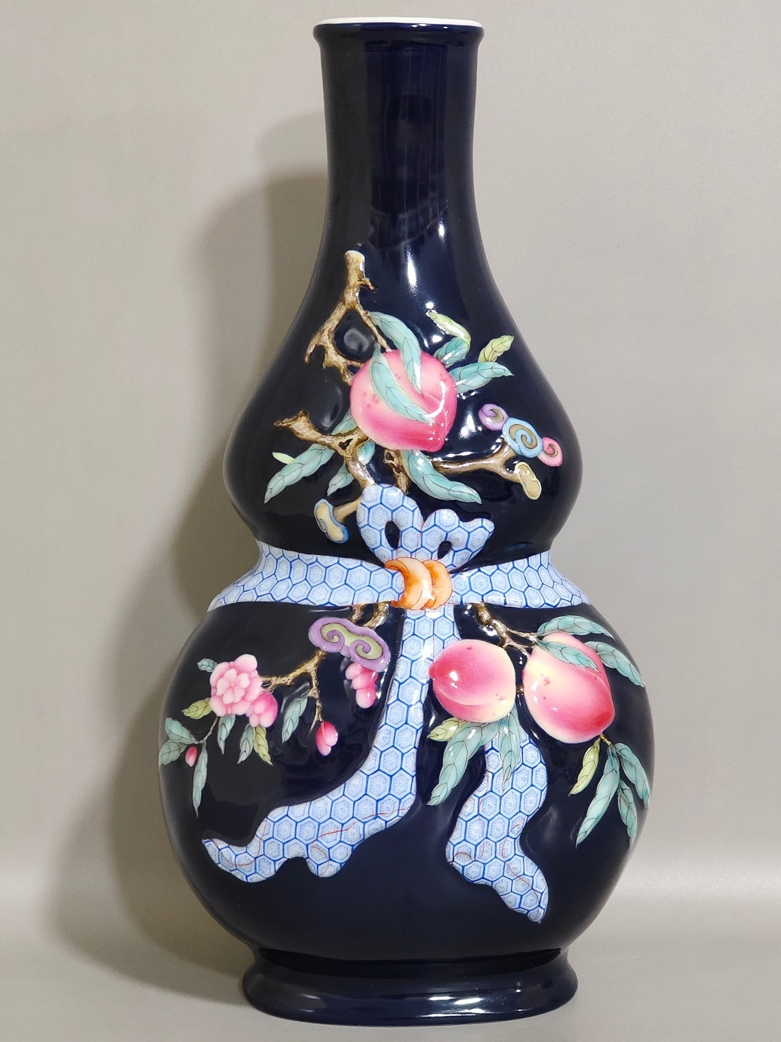 Qing Dynasty Qianlong Festival blue glazed relief vase with longevity peach gourd