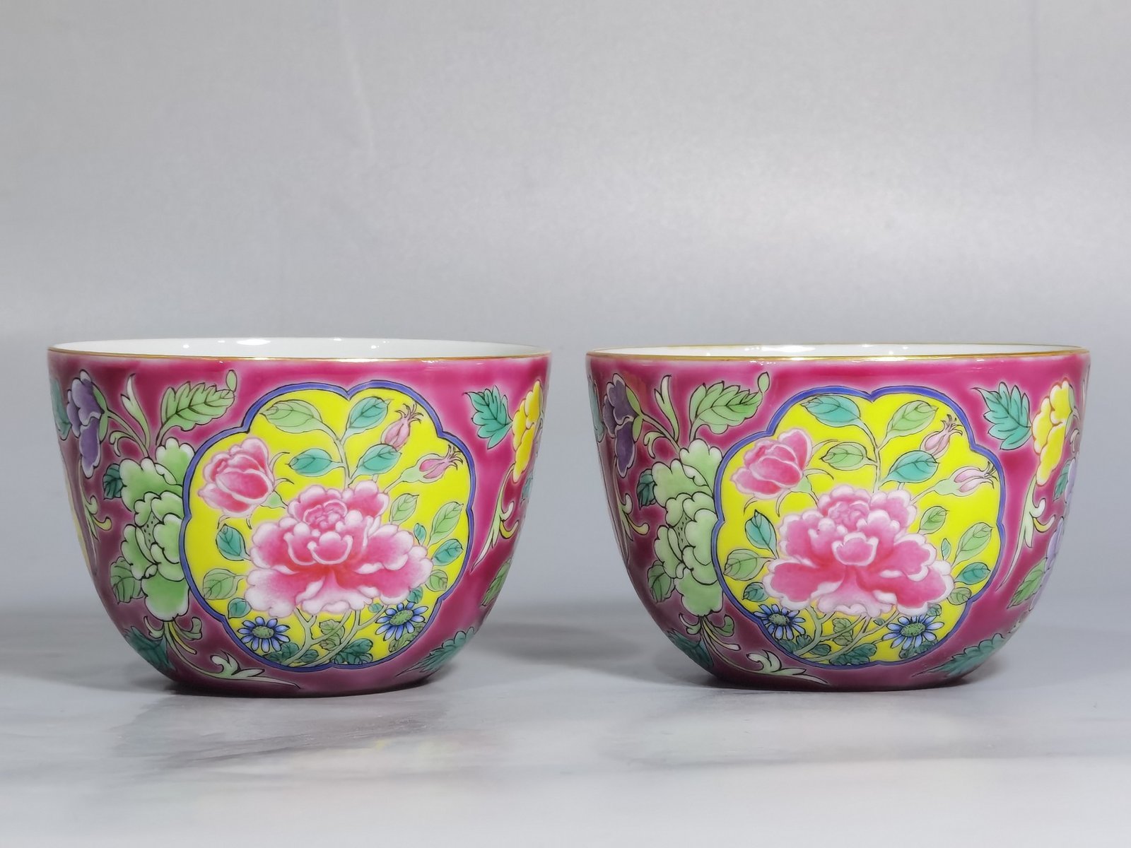 Qing Dynasty Kangxi pair of enamel and rouge ground consecrated cups with floral patterns