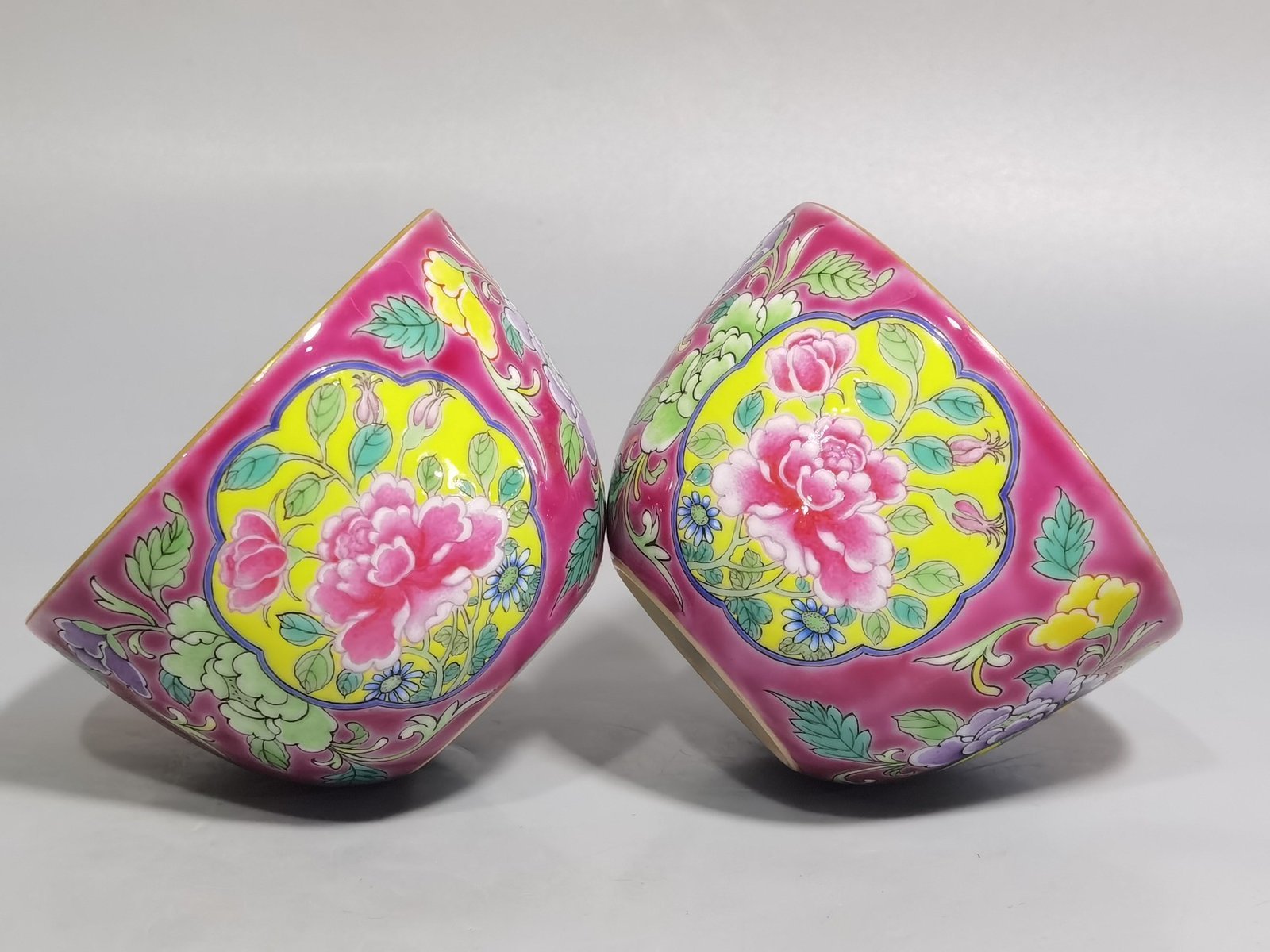 Qing Dynasty Kangxi pair of enamel and rouge ground consecrated cups with floral patterns