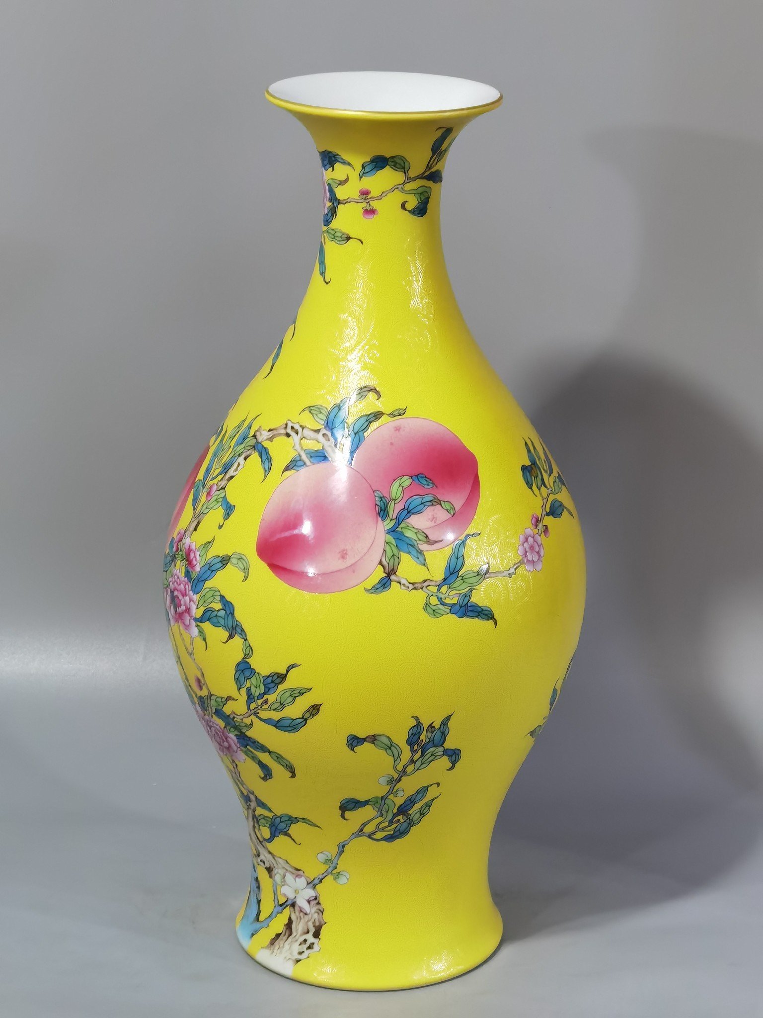 Qing Dynasty Yongzheng yellow ground rolling road pastel eight peaches and five blessings olive vase