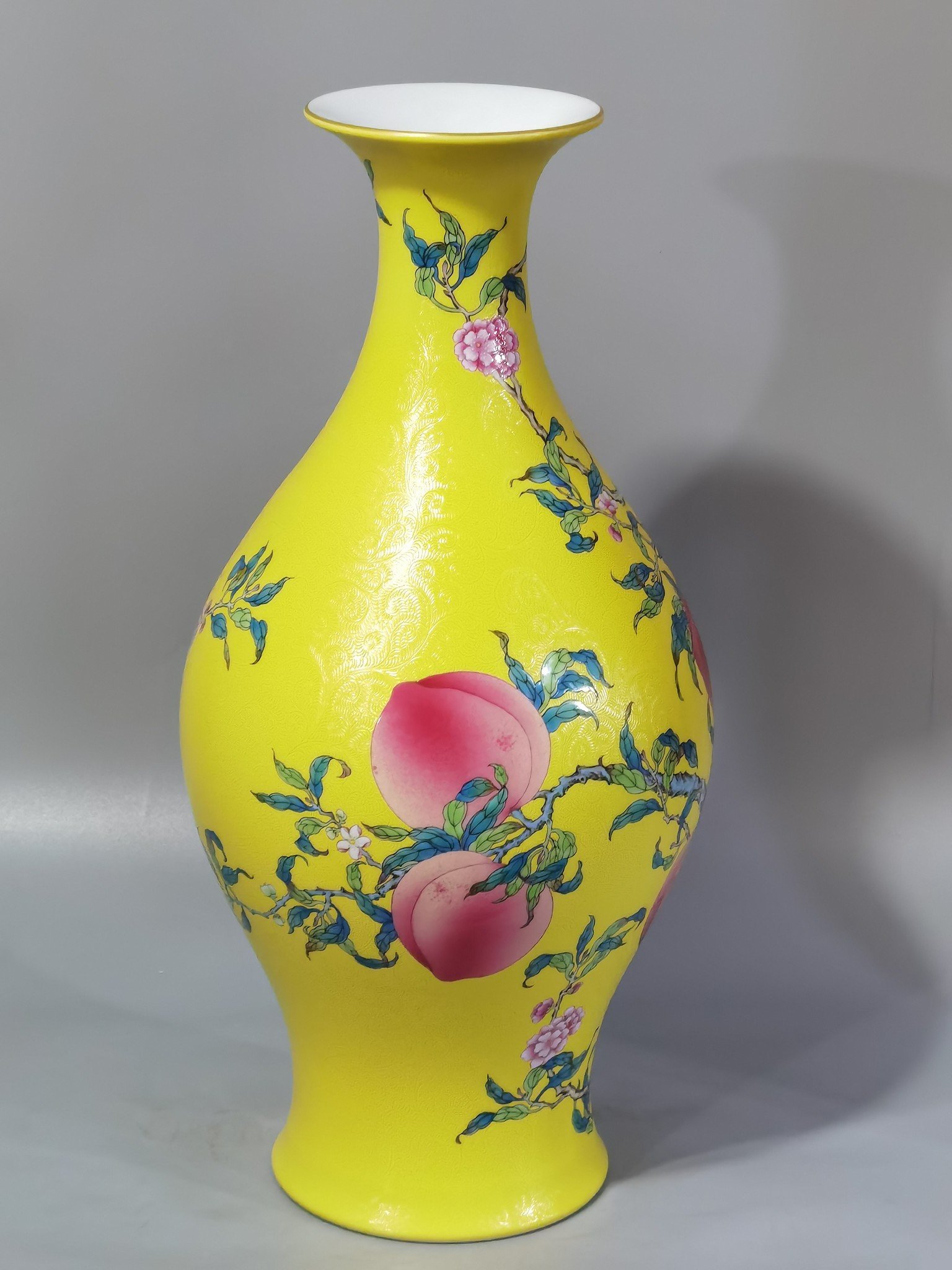 Qing Dynasty Yongzheng yellow ground rolling road pastel eight peaches and five blessings olive vase