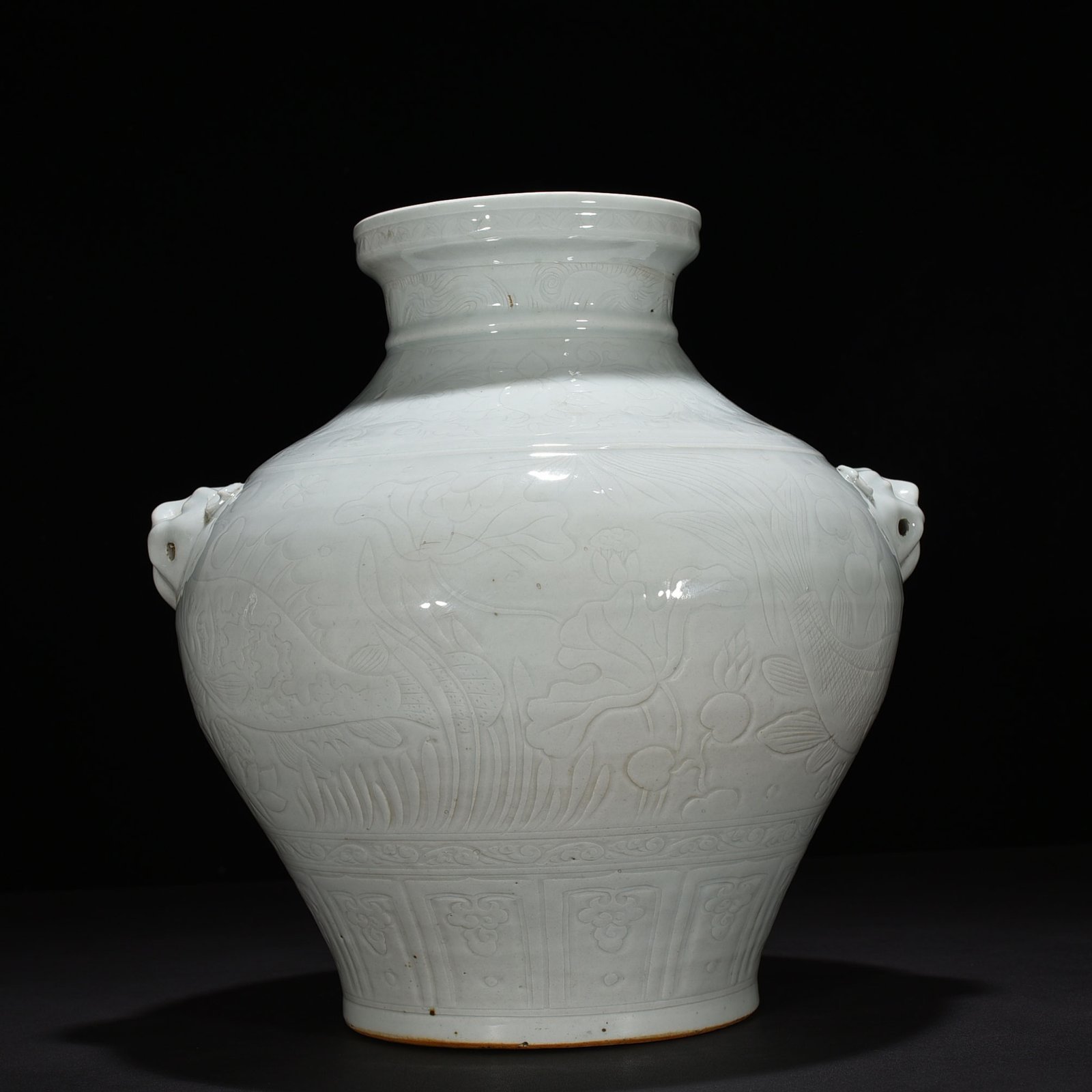 Yuan Dynasty egg white glaze carved animal ear jar with fish and algae pattern