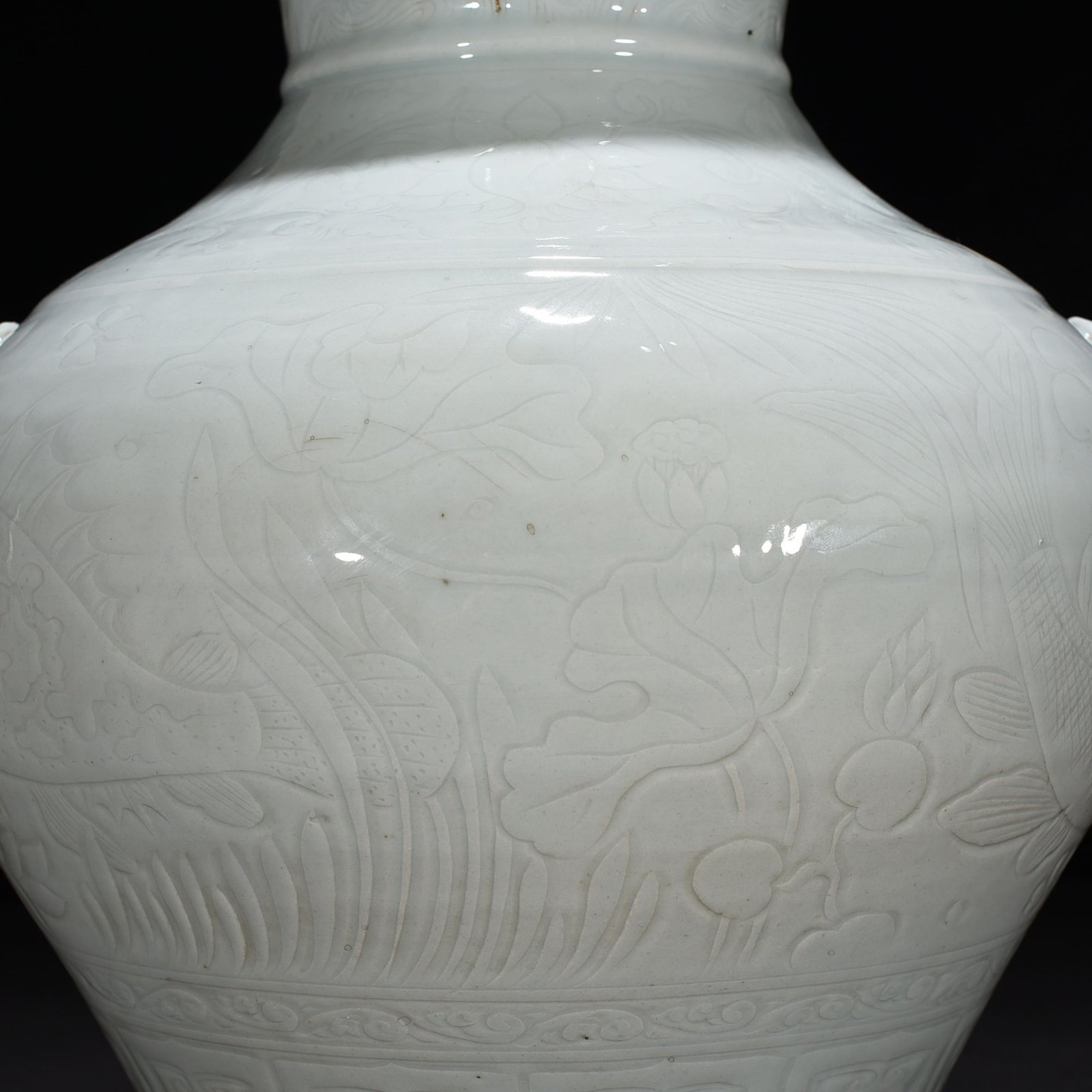 Yuan Dynasty egg white glaze carved animal ear jar with fish and algae pattern