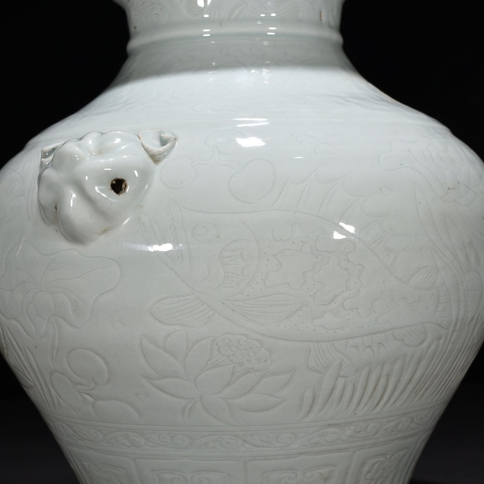 Yuan Dynasty egg white glaze carved animal ear jar with fish and algae pattern