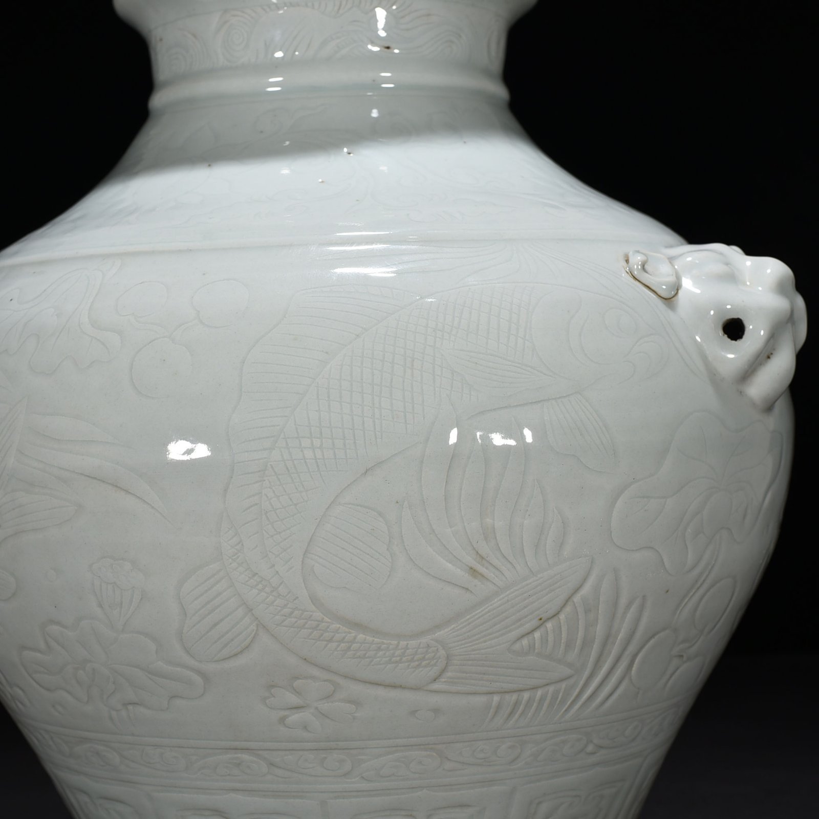 Yuan Dynasty egg white glaze carved animal ear jar with fish and algae pattern