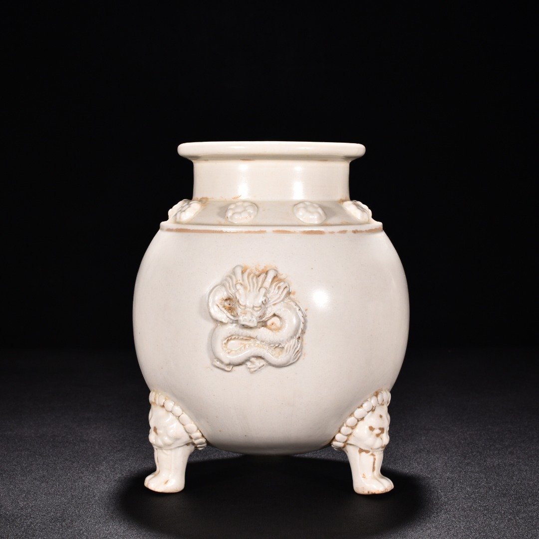 Tang Dynasty Xing kiln white porcelain laminated dragon pattern three-legged jar