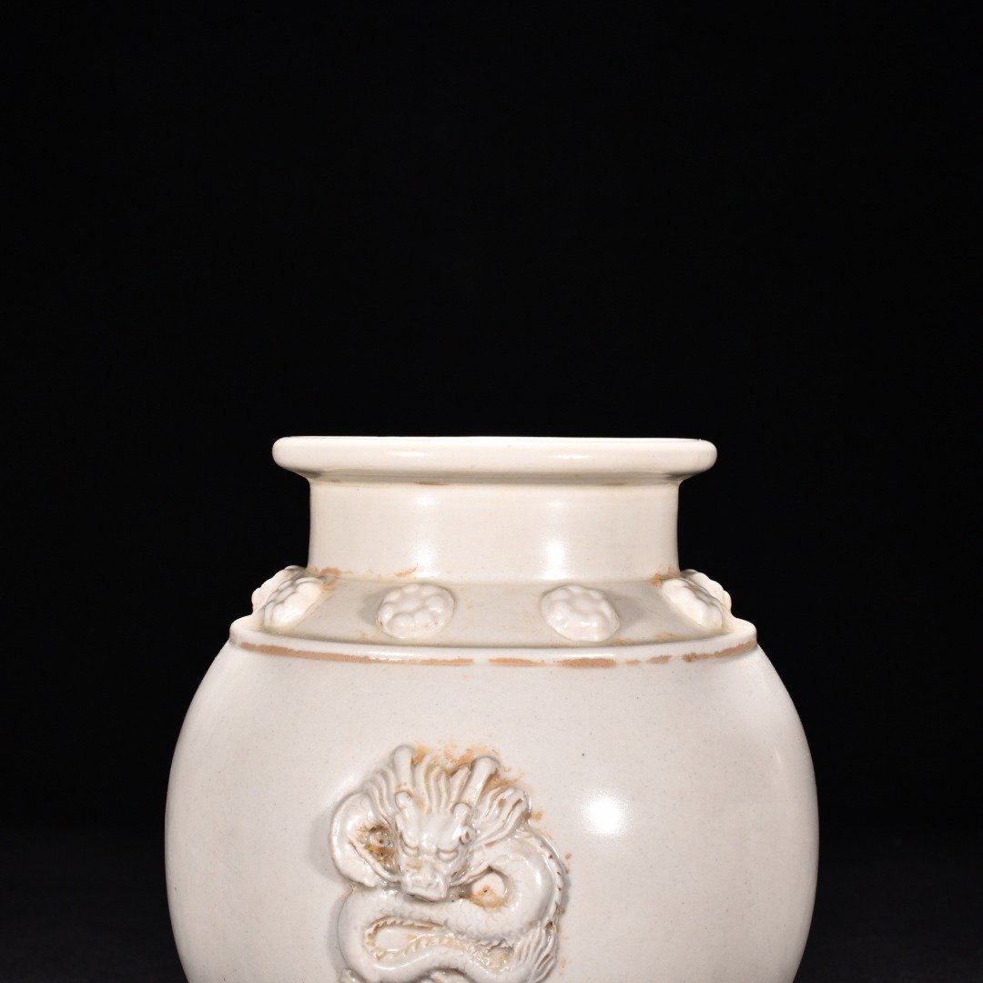 Tang Dynasty Xing kiln white porcelain laminated dragon pattern three-legged jar
