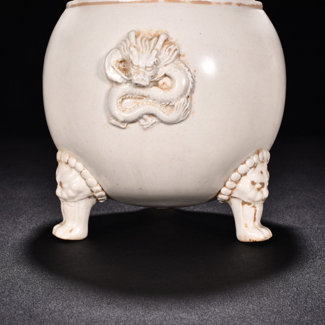 Tang Dynasty Xing kiln white porcelain laminated dragon pattern three-legged jar