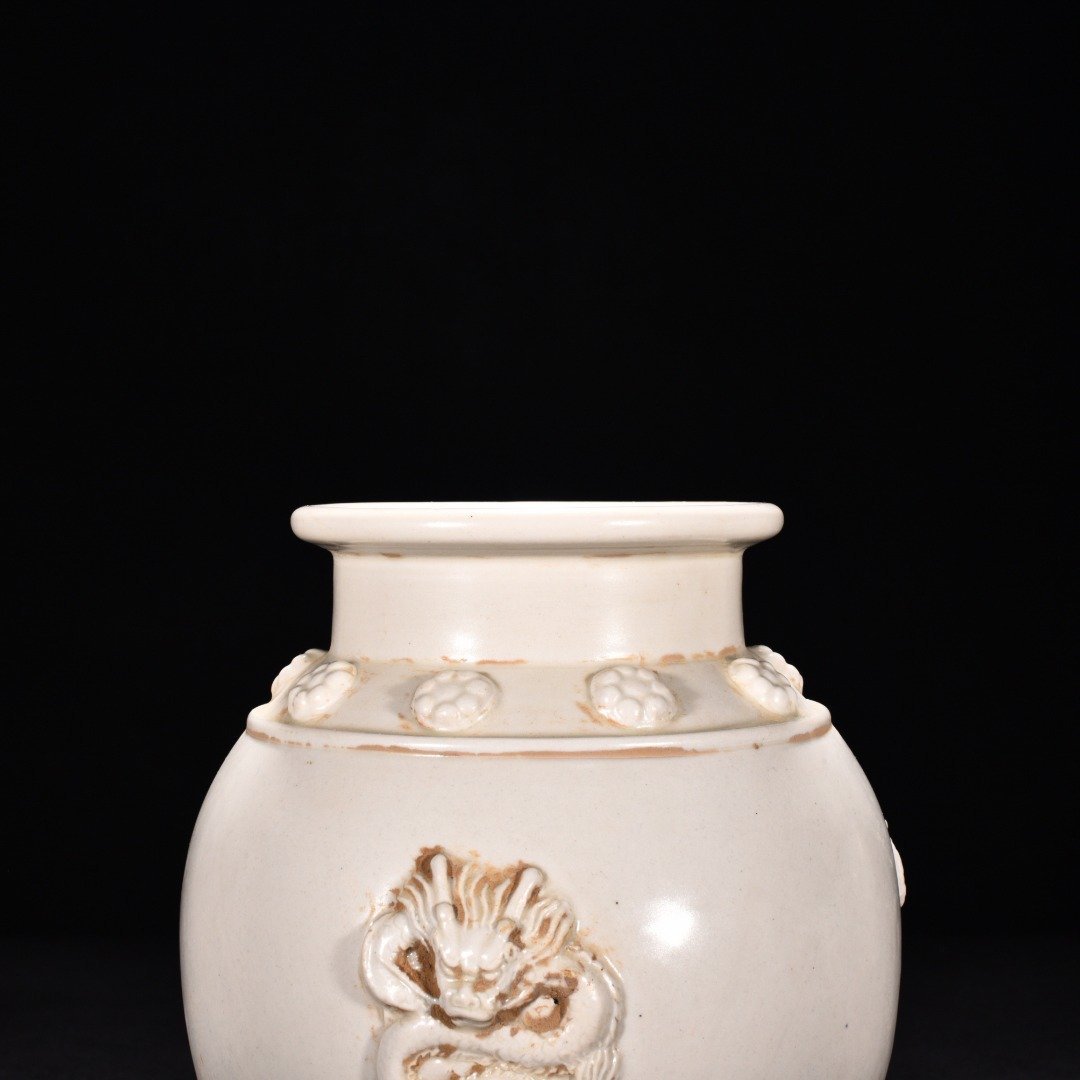 Tang Dynasty Xing kiln white porcelain laminated dragon pattern three-legged jar