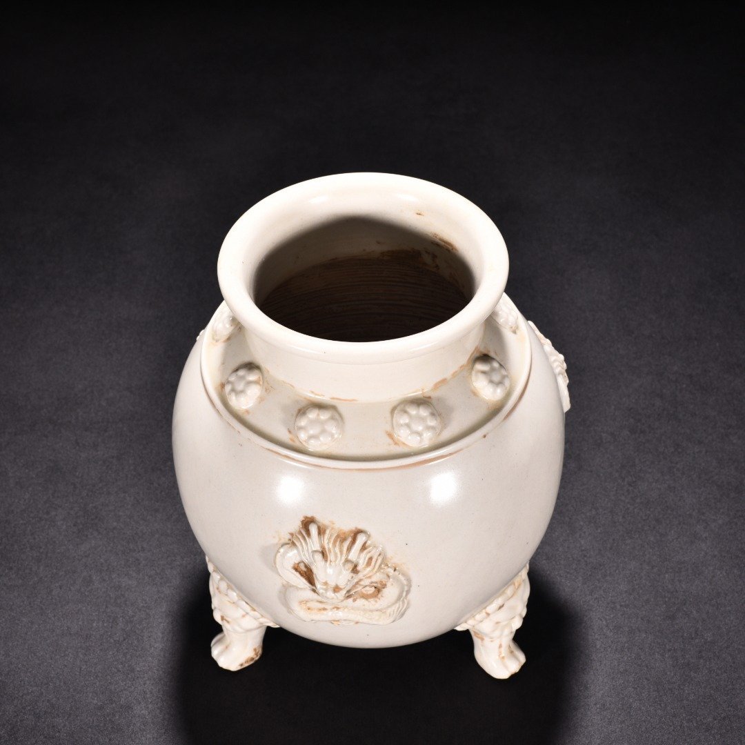 Tang Dynasty Xing kiln white porcelain laminated dragon pattern three-legged jar