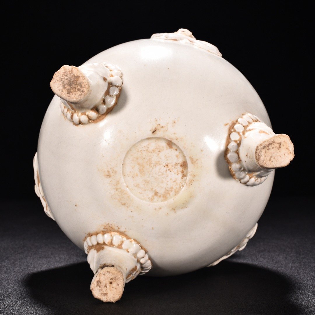 Tang Dynasty Xing kiln white porcelain laminated dragon pattern three-legged jar