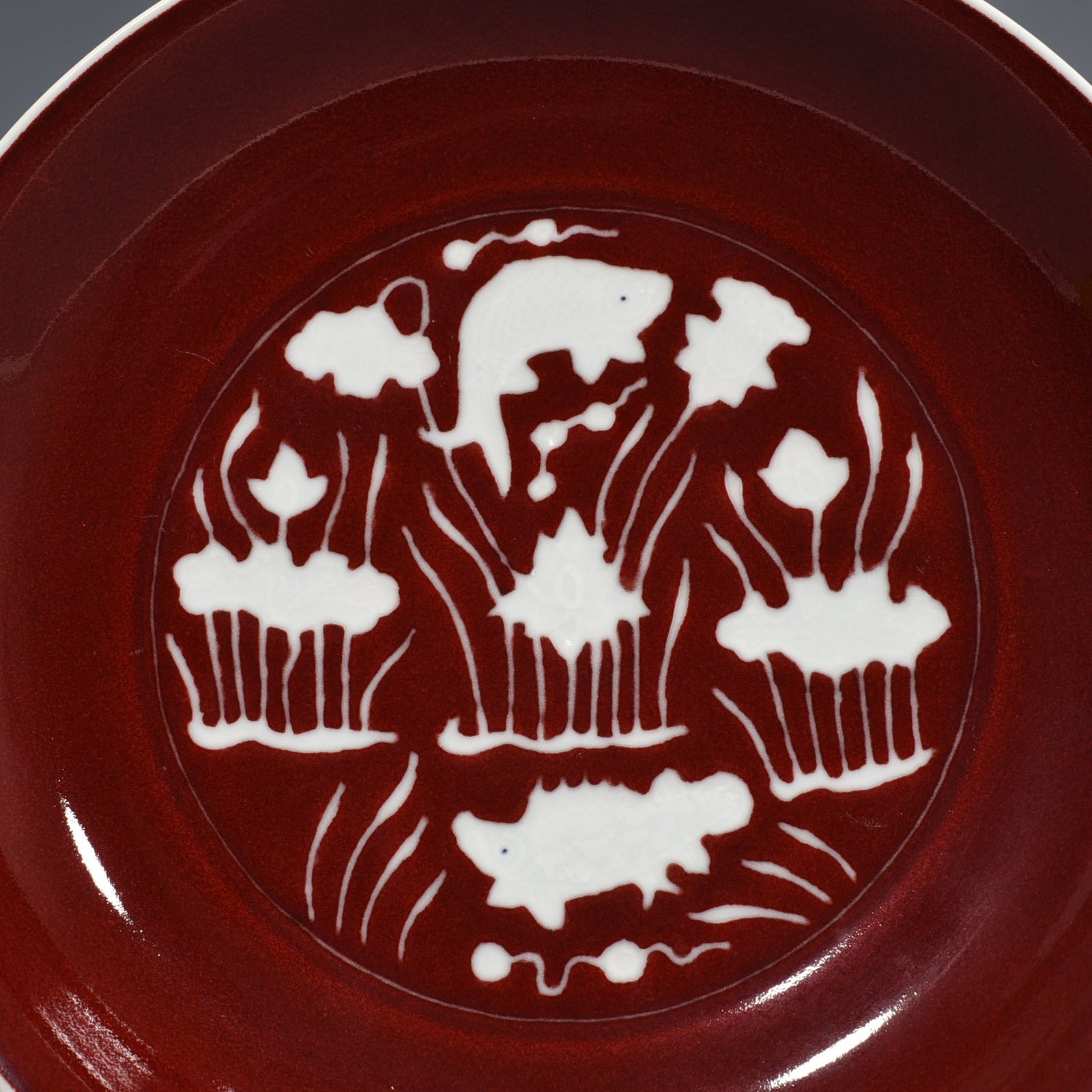 Ming Dynasty Xuande Festival red glaze engraved fish and algae pattern plate