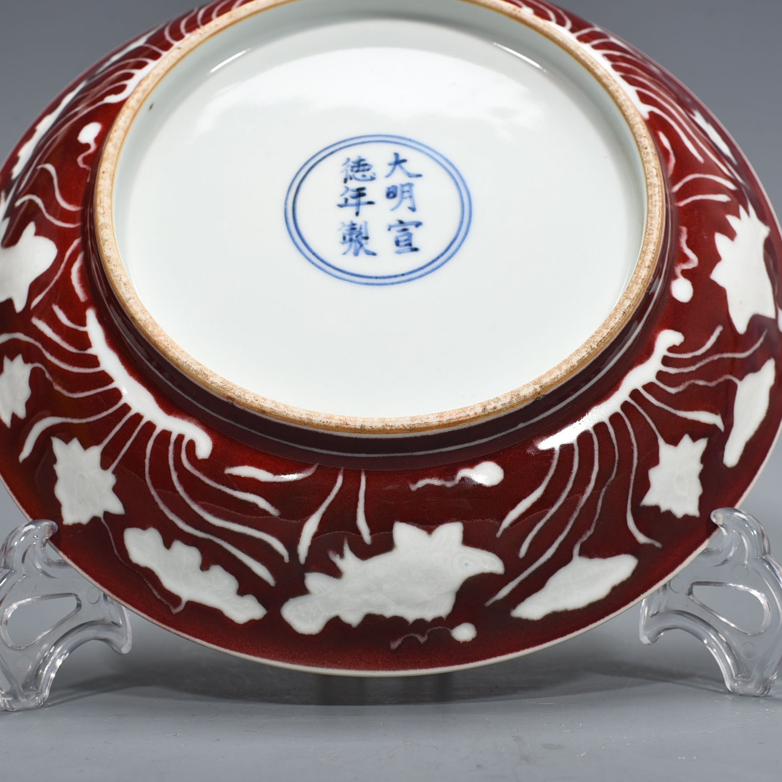 Ming Dynasty Xuande Festival red glaze engraved fish and algae pattern plate