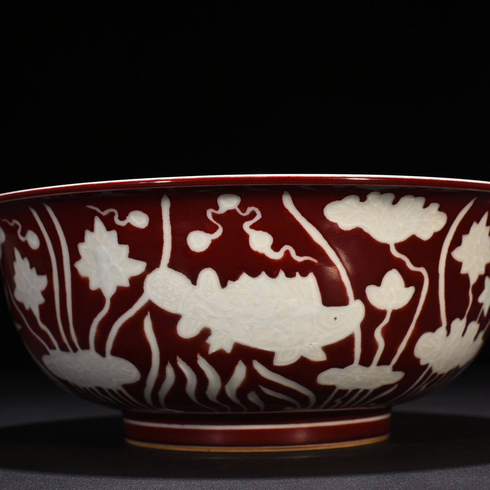 Ming Dynasty Xuande Festival red glaze engraved fish and algae pattern bowl