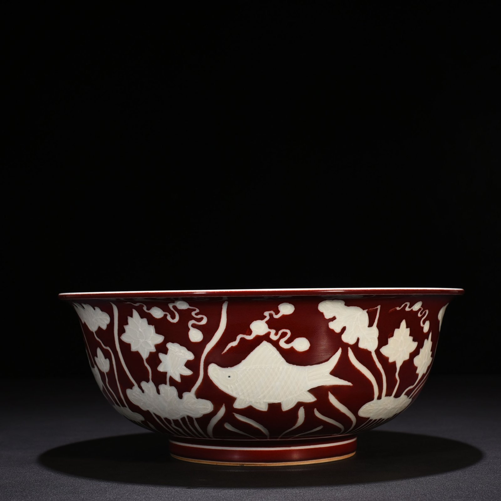 Ming Dynasty Xuande Festival red glaze engraved fish and algae pattern bowl
