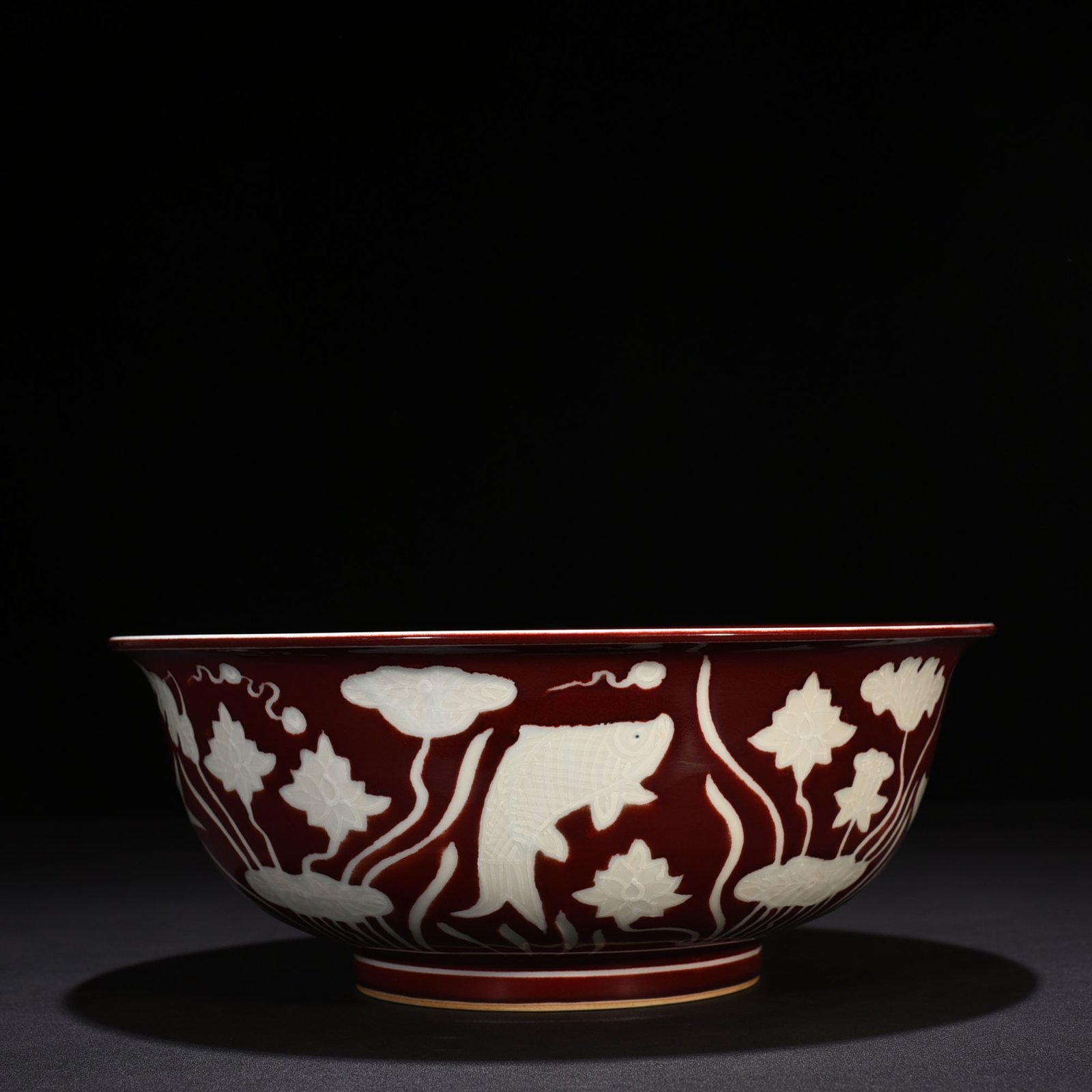 Ming Dynasty Xuande Festival red glaze engraved fish and algae pattern bowl