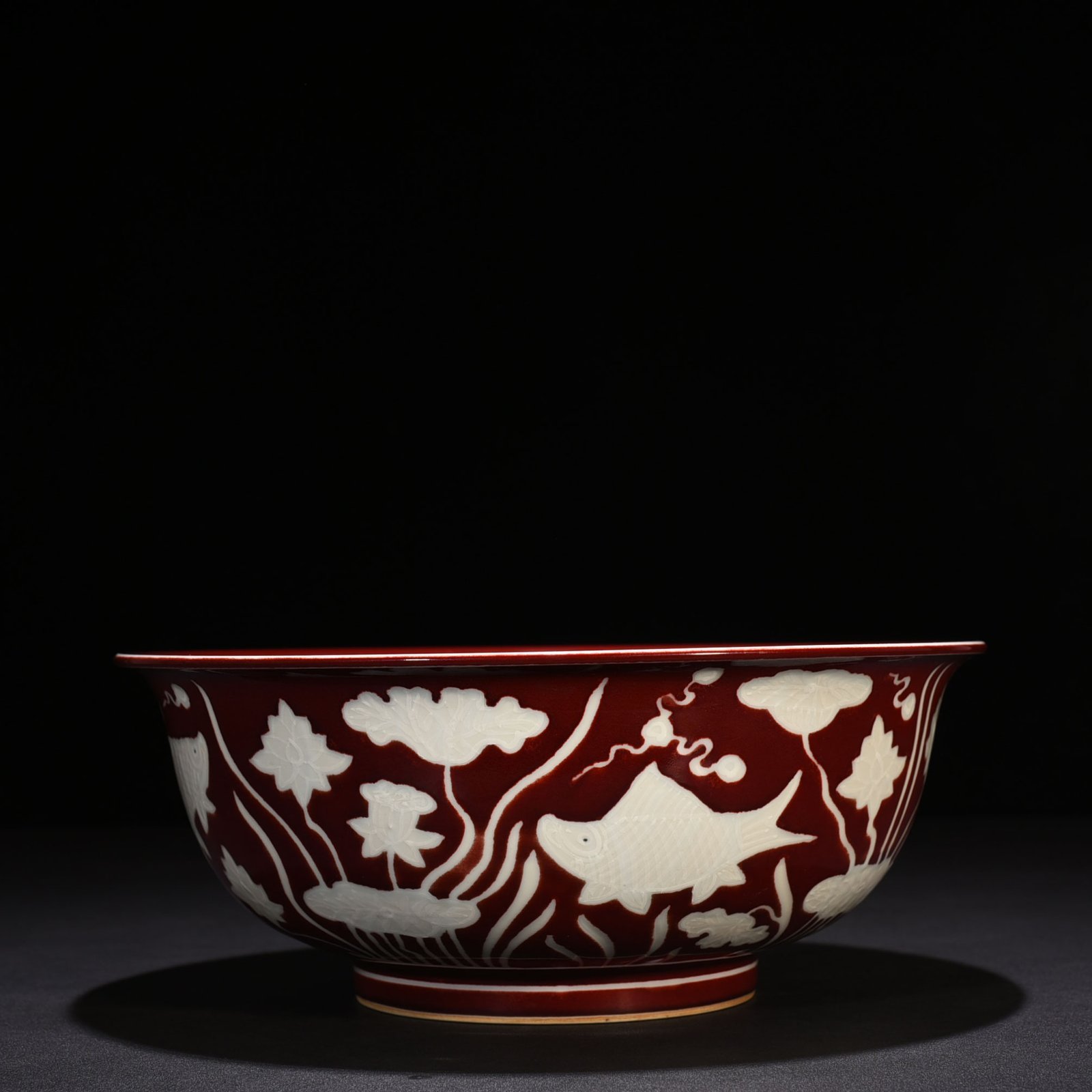 Ming Dynasty Xuande Festival red glaze engraved fish and algae pattern bowl