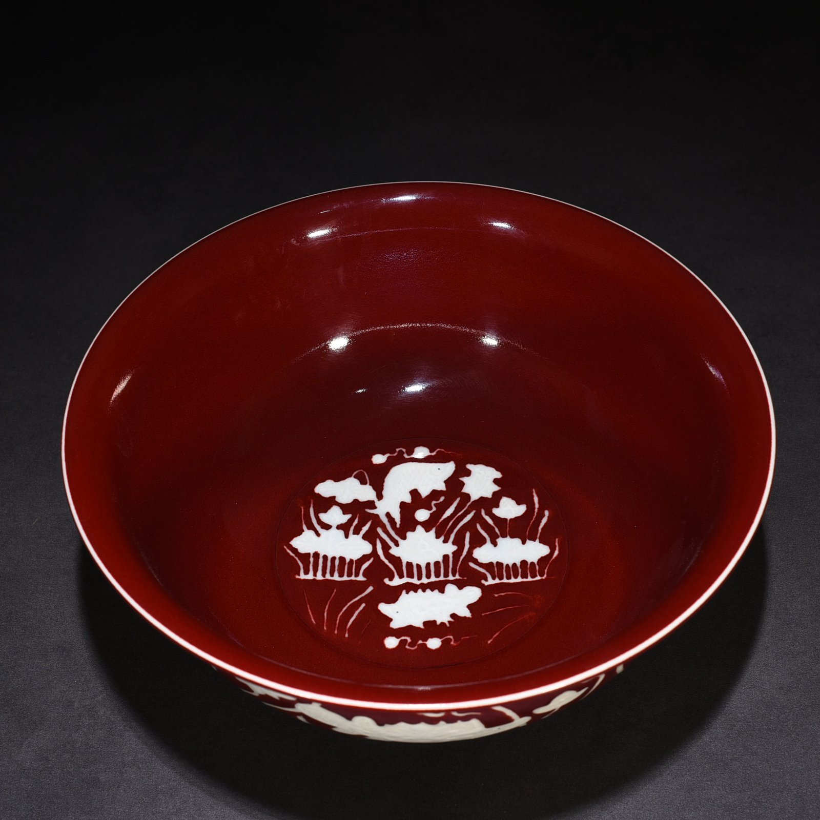 Ming Dynasty Xuande Festival red glaze engraved fish and algae pattern bowl