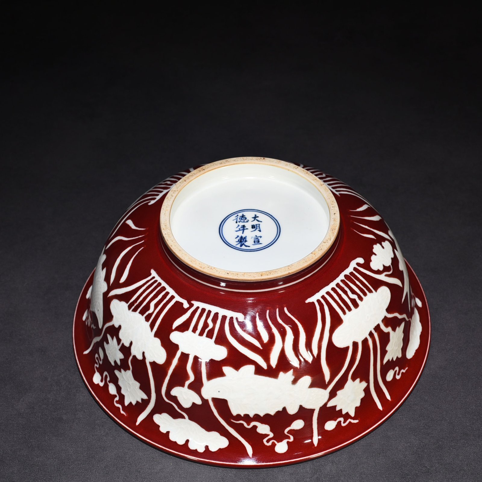 Ming Dynasty Xuande Festival red glaze engraved fish and algae pattern bowl