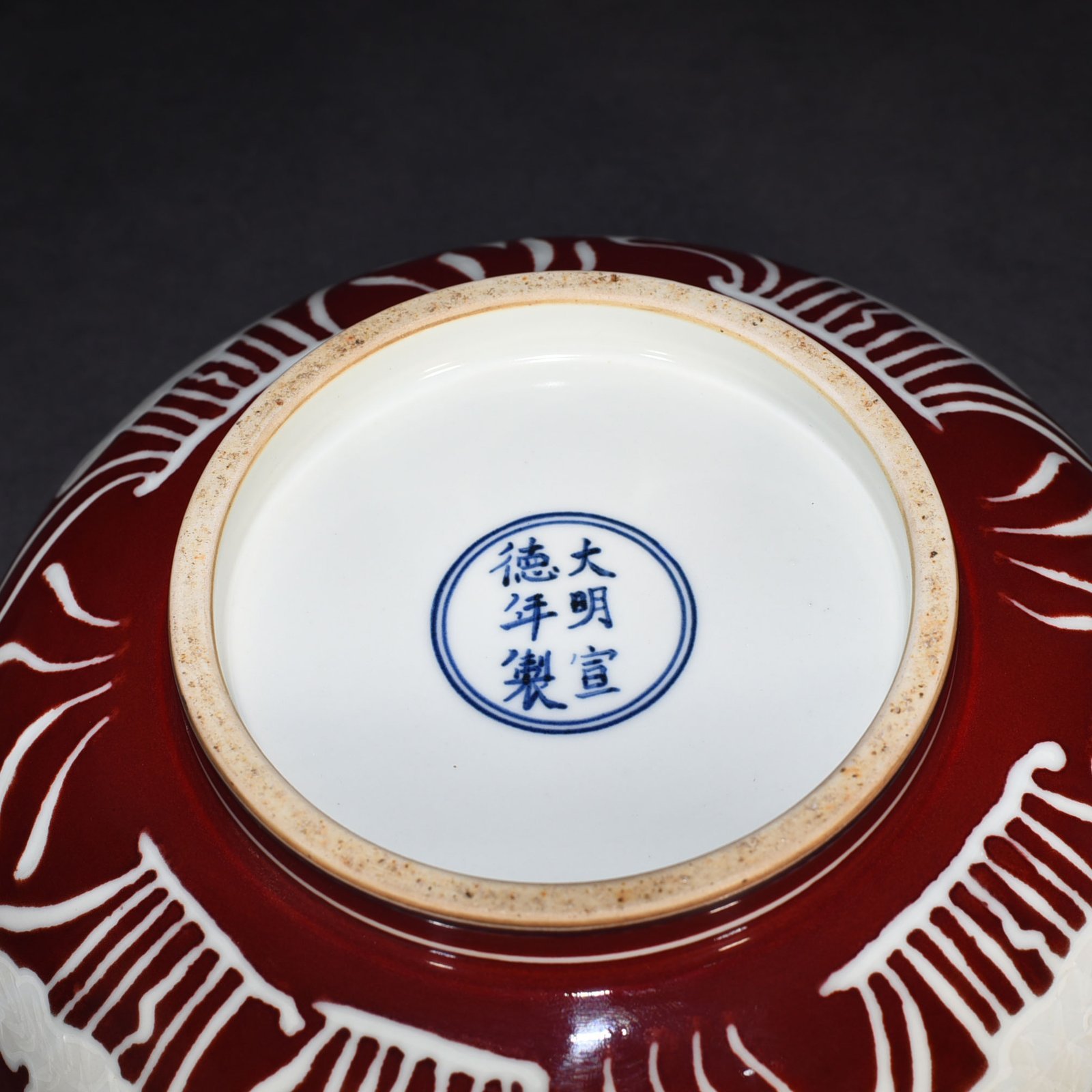 Ming Dynasty Xuande Festival red glaze engraved fish and algae pattern bowl