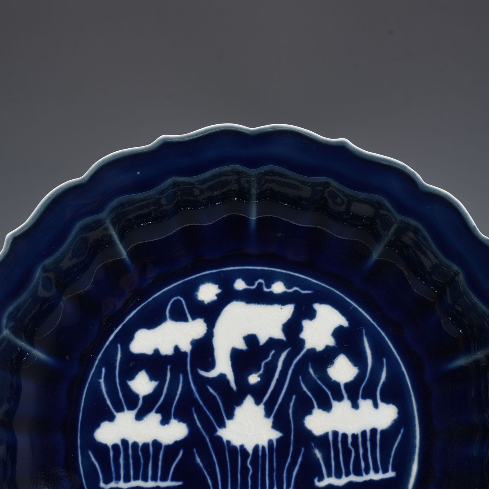 Ming Dynasty Xuande Festival blue glaze engraved fish and algae folding plate