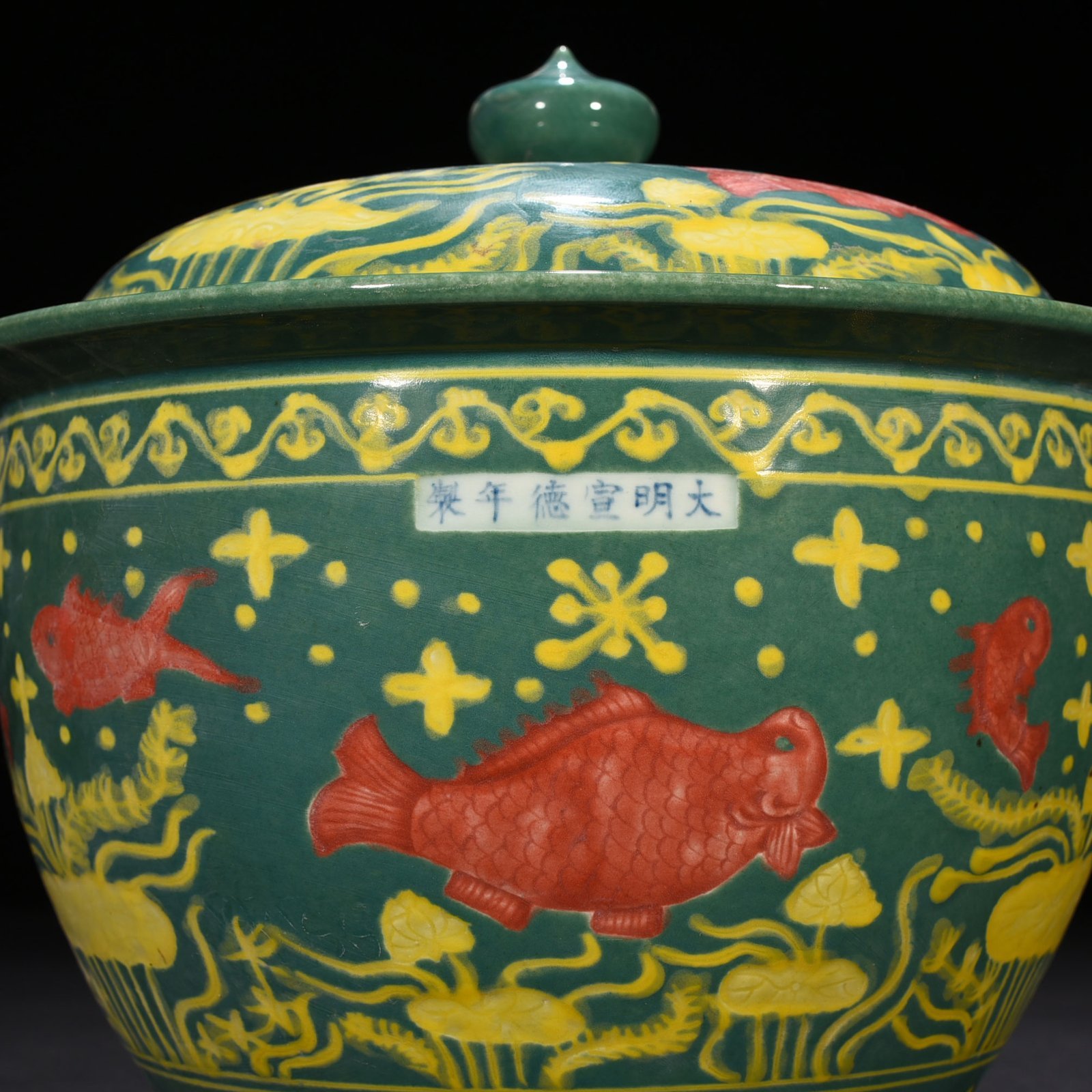 Ming Dynasty Xuande green glaze carved fish and algae pattern lid jar