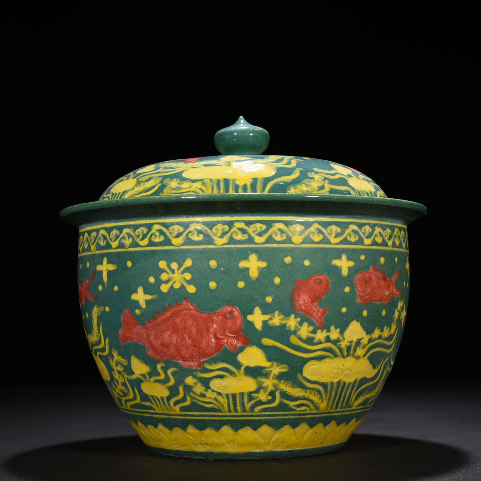 Ming Dynasty Xuande green glaze carved fish and algae pattern lid jar