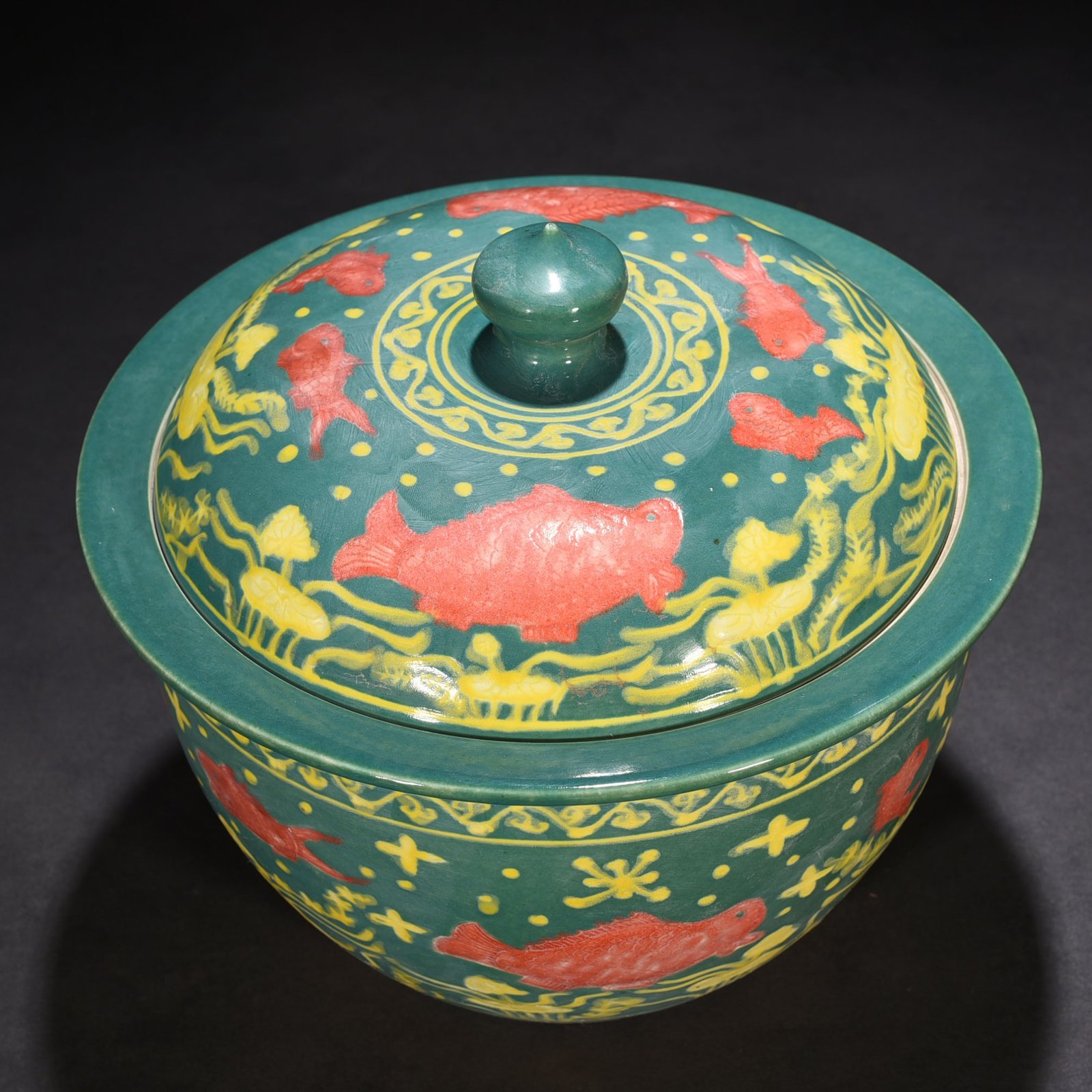 Ming Dynasty Xuande green glaze carved fish and algae pattern lid jar
