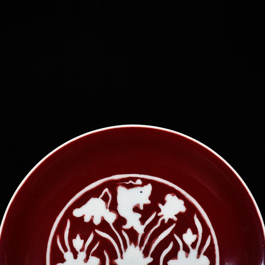 Ming Dynasty Xuande Ji red glaze engraved fish and algae pattern plate
