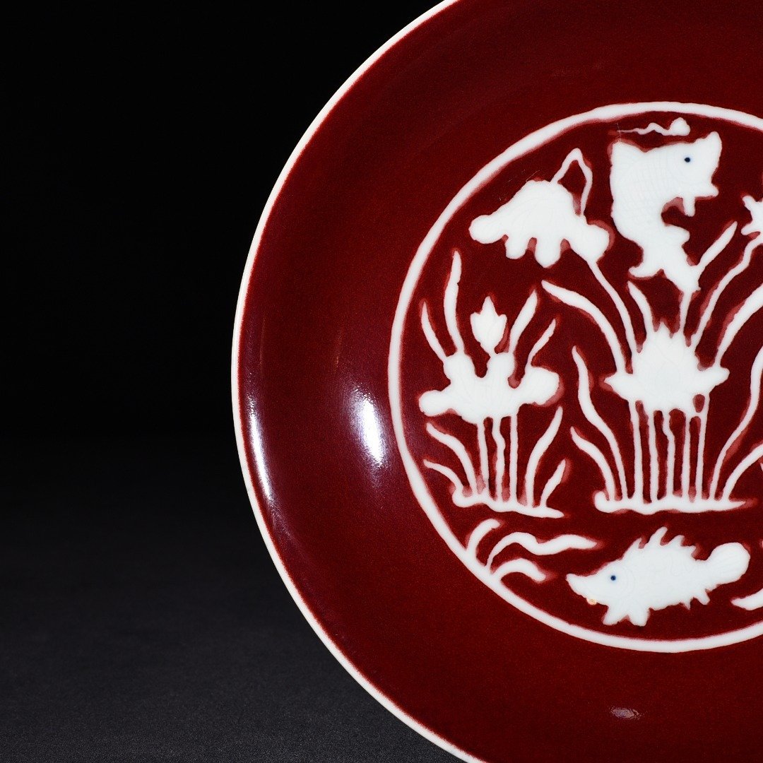 Ming Dynasty Xuande Ji red glaze engraved fish and algae pattern plate