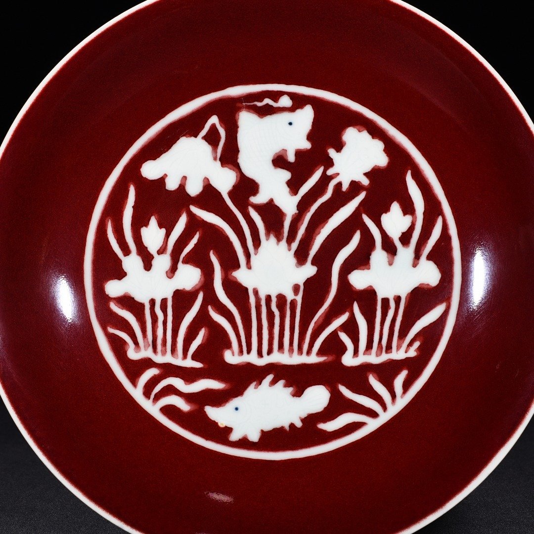 Ming Dynasty Xuande Ji red glaze engraved fish and algae pattern plate