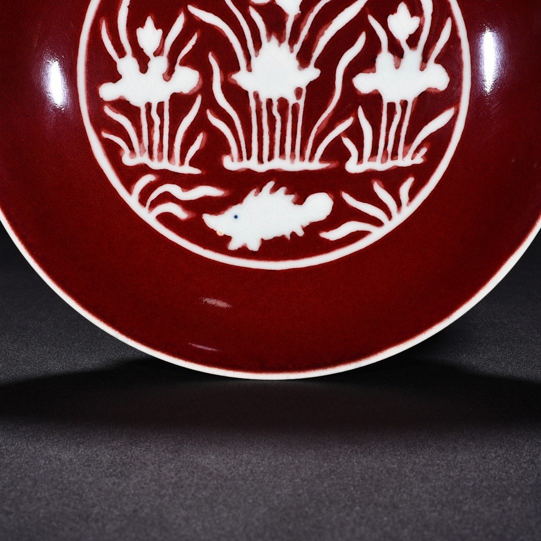 Ming Dynasty Xuande Ji red glaze engraved fish and algae pattern plate