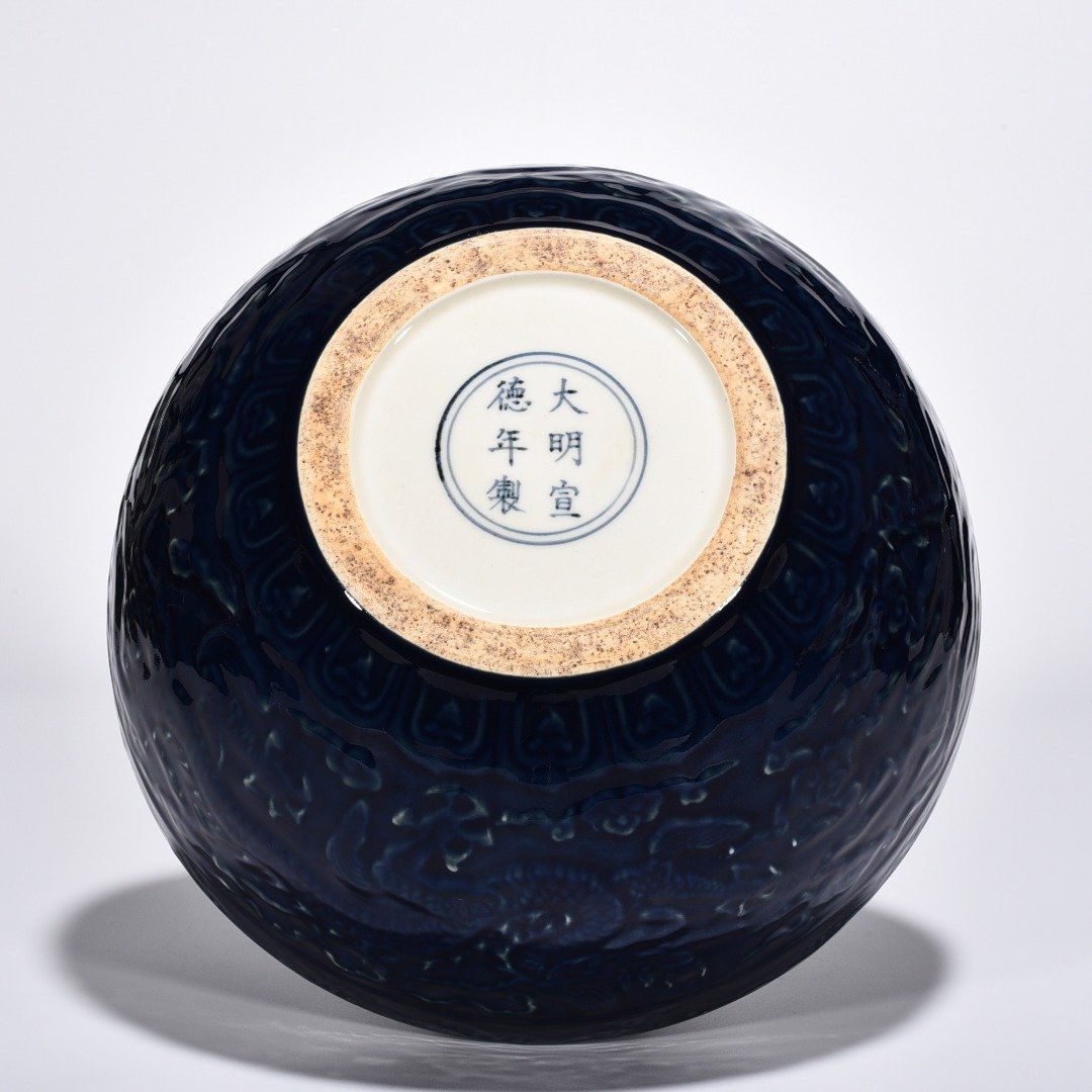 Ming Dynasty Xuande blue glaze bowl with carved cloud and dragon pattern