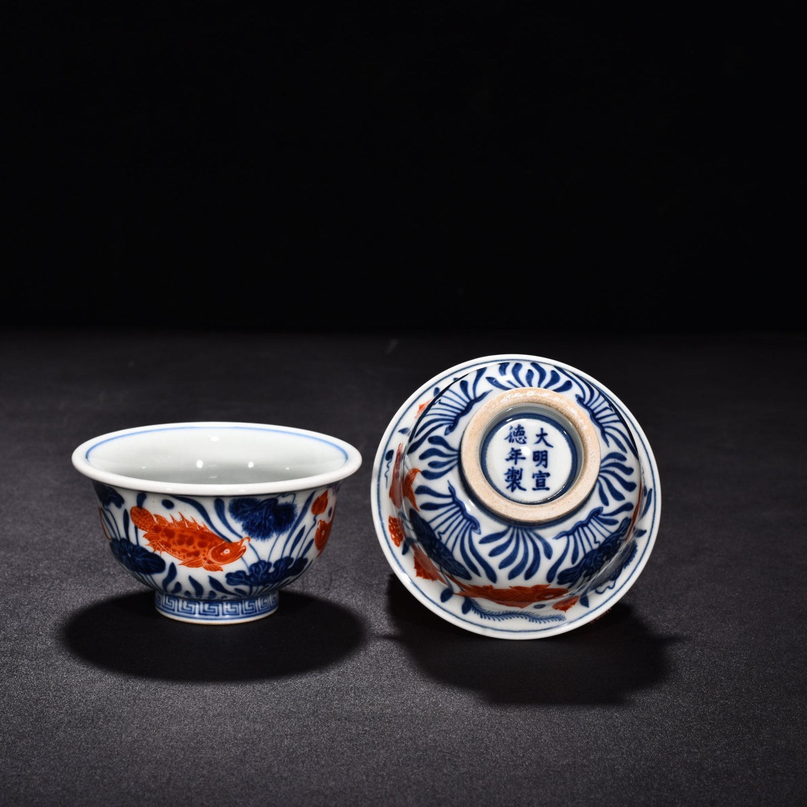 Ming Dynasty Xuande blue and white alum red fish and algae pattern pressed hand cup