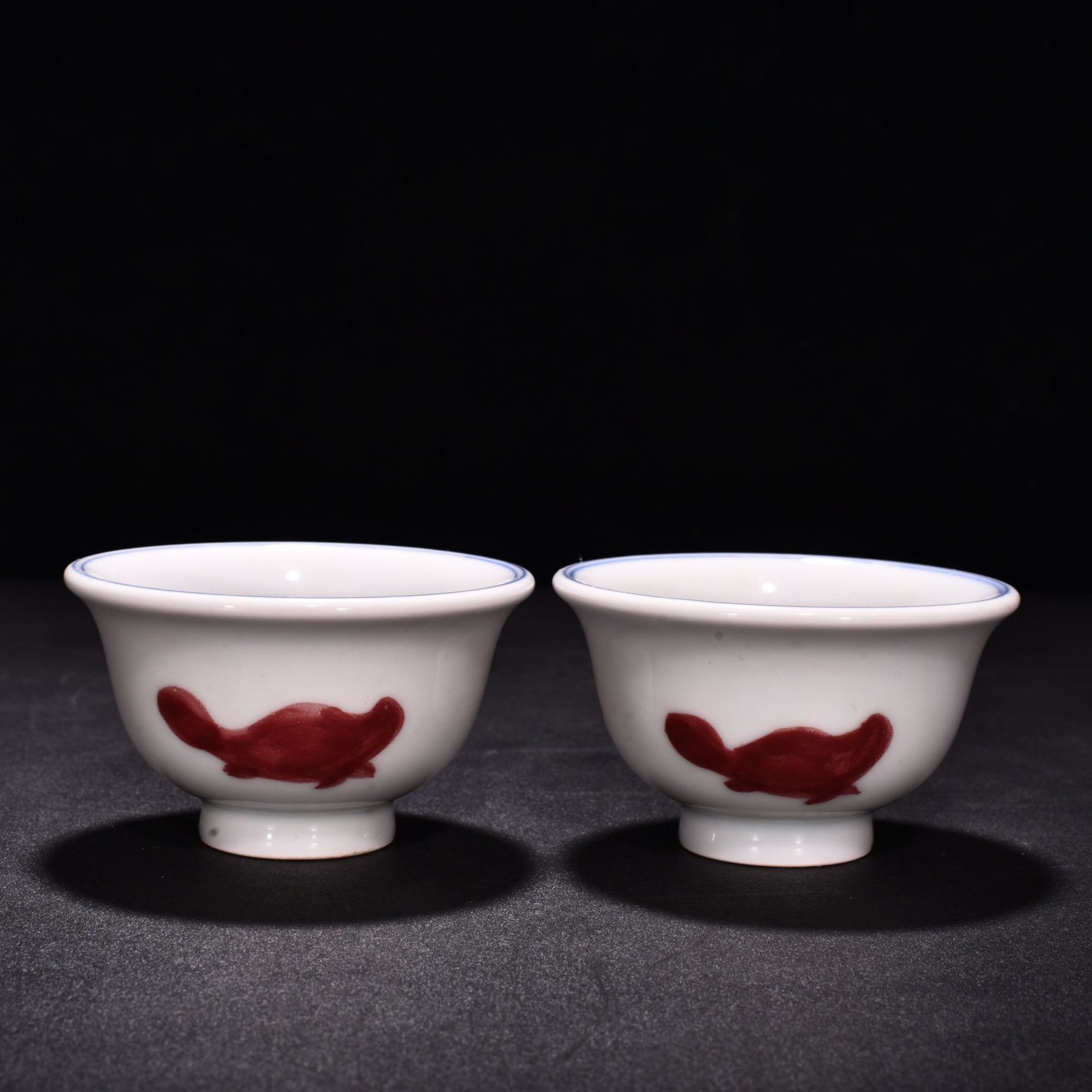 Ming Dynasty Xuande blue and white underglaze red fish and algae pattern three-fish pressing cup