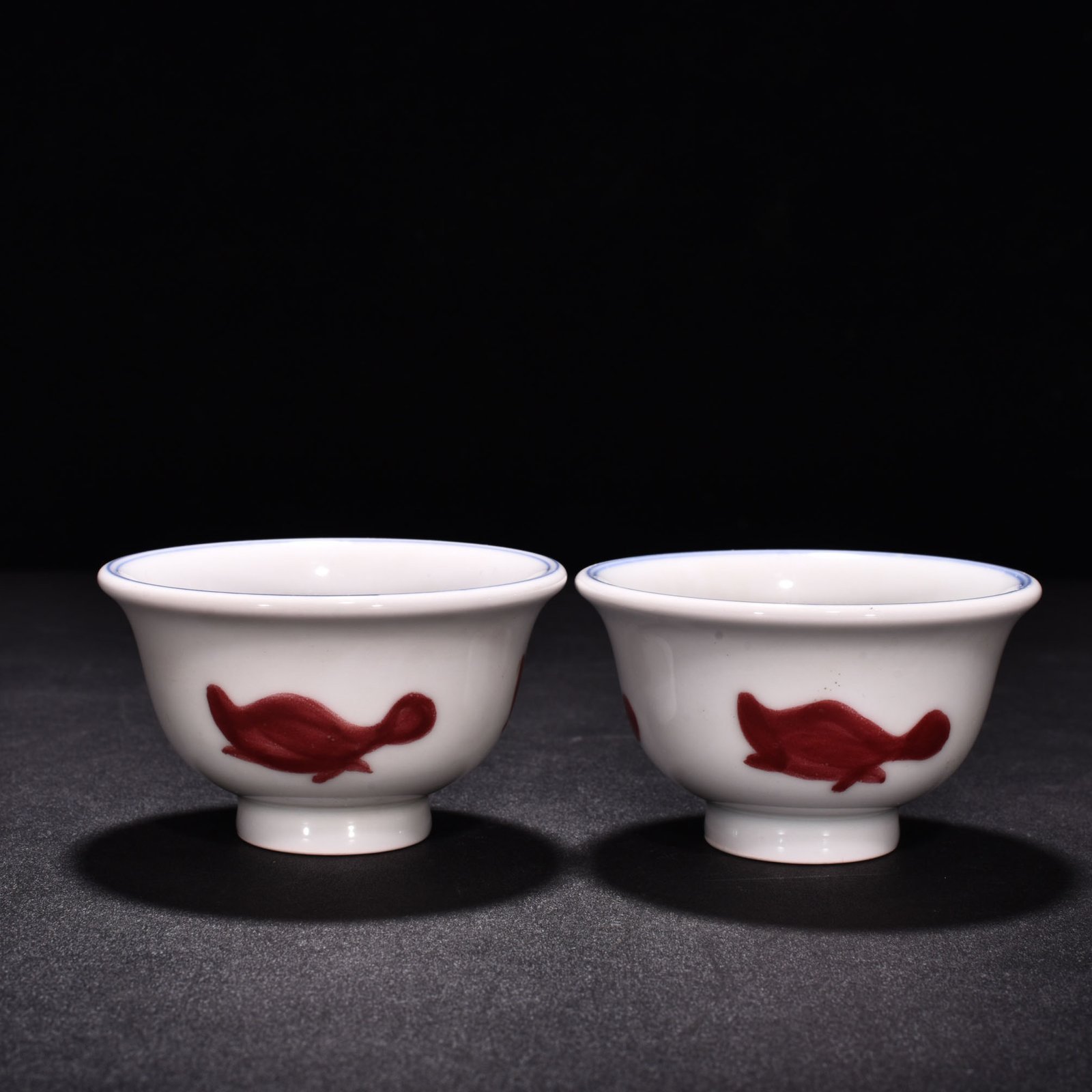 Ming Dynasty Xuande blue and white underglaze red fish and algae pattern three-fish pressing cup