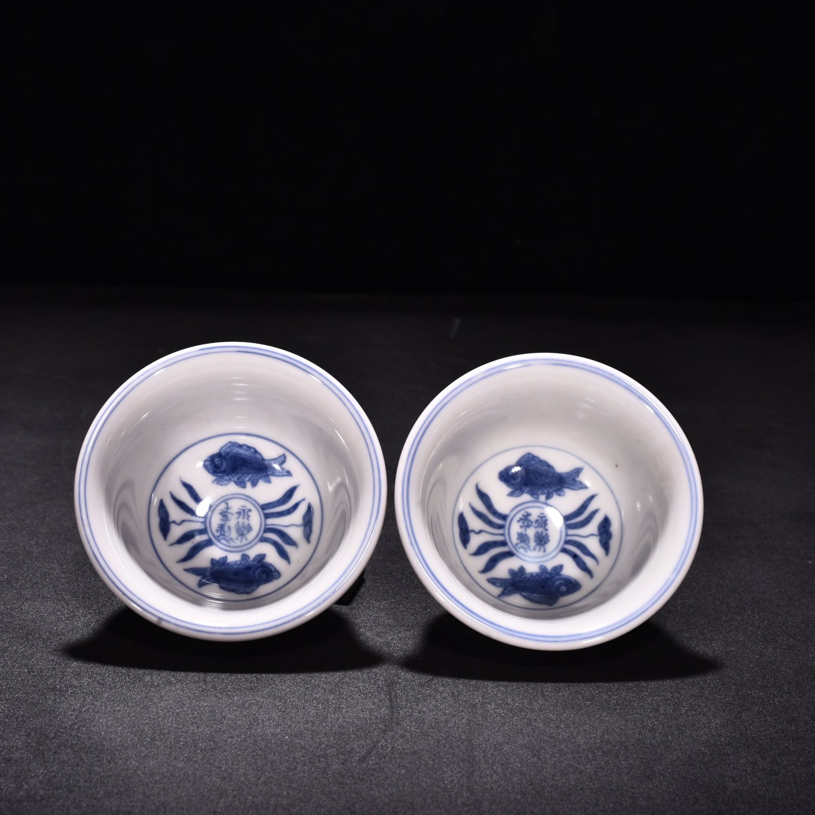Ming Dynasty Xuande blue and white underglaze red fish and algae pattern three-fish pressing cup