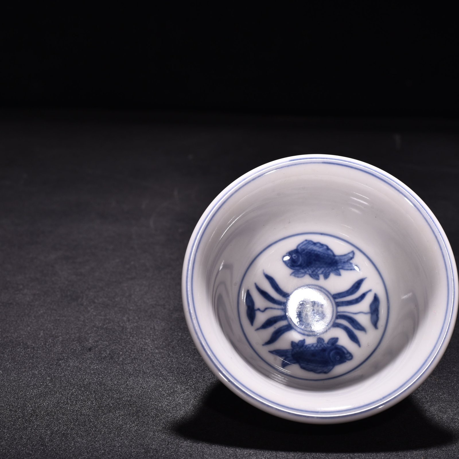 Ming Dynasty Xuande blue and white underglaze red fish and algae pattern three-fish pressing cup