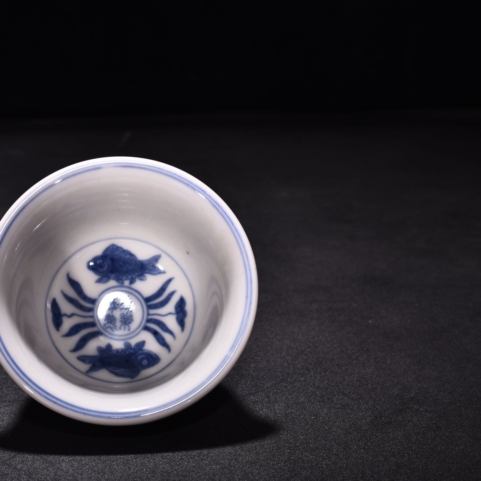 Ming Dynasty Xuande blue and white underglaze red fish and algae pattern three-fish pressing cup
