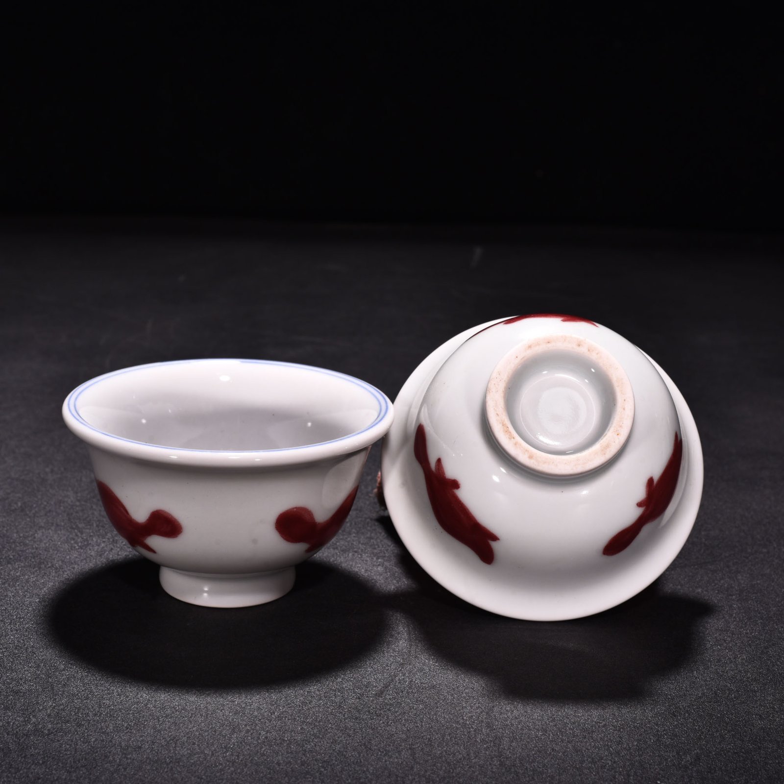 Ming Dynasty Xuande blue and white underglaze red fish and algae pattern three-fish pressing cup