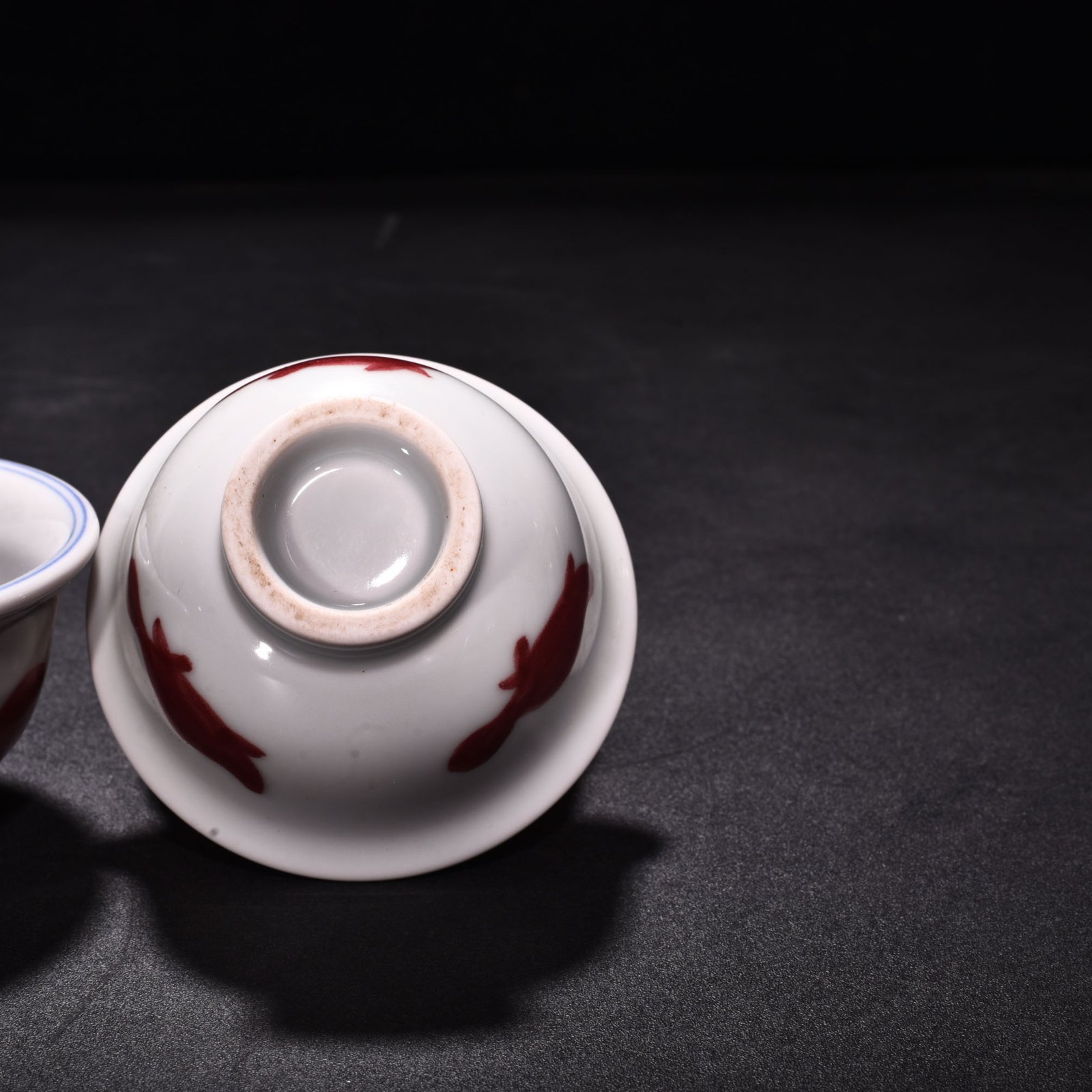 Ming Dynasty Xuande blue and white underglaze red fish and algae pattern three-fish pressing cup