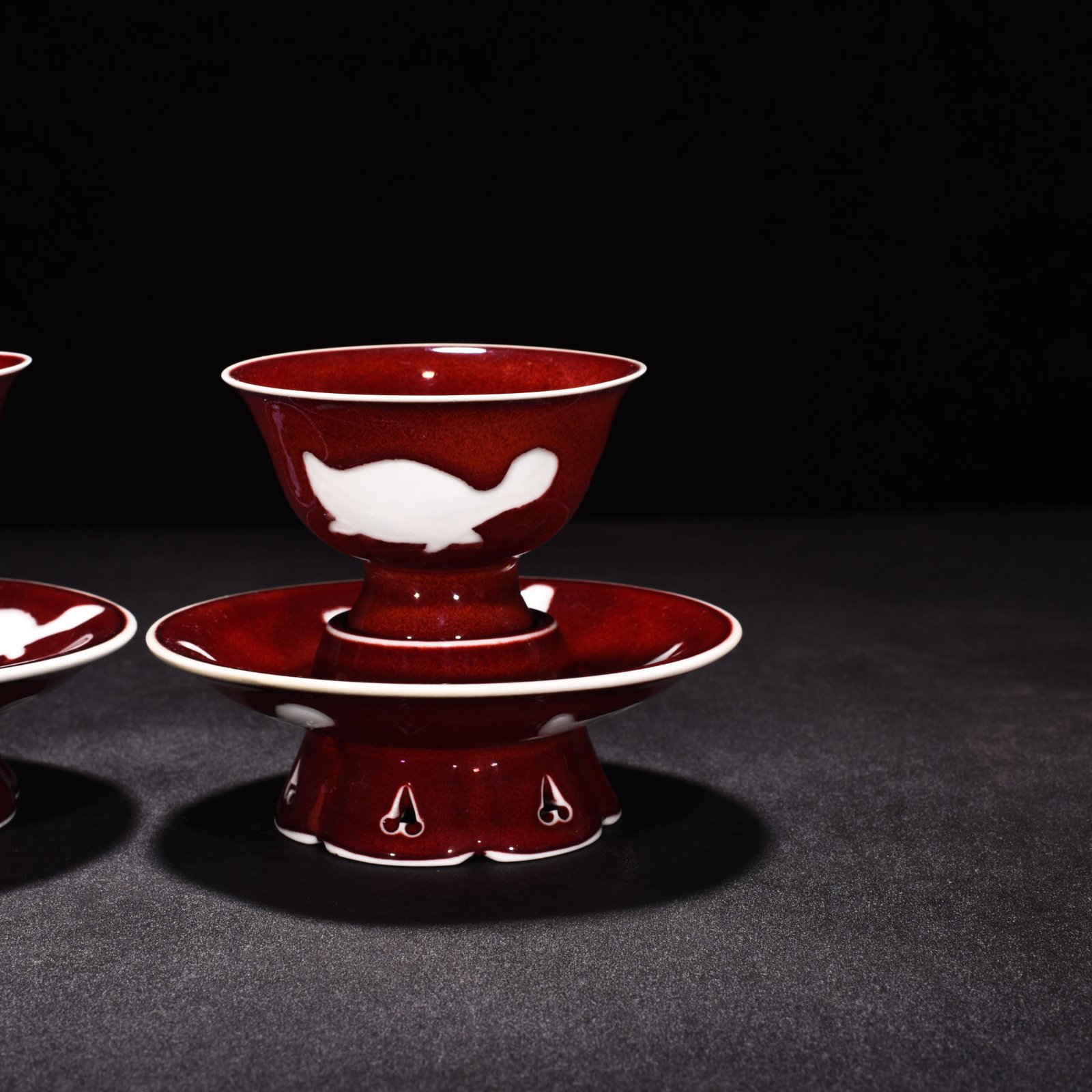 Ming Dynasty Yongle ruby ​​red glazed white engraved three-fish lamp holder