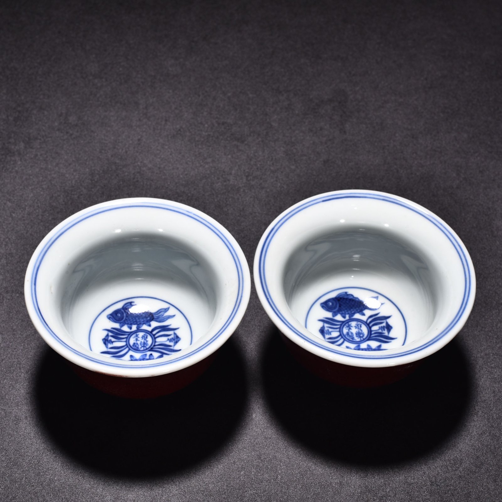 Ming Dynasty Yongle blue and white fish and algae and red glaze pressed hand cup