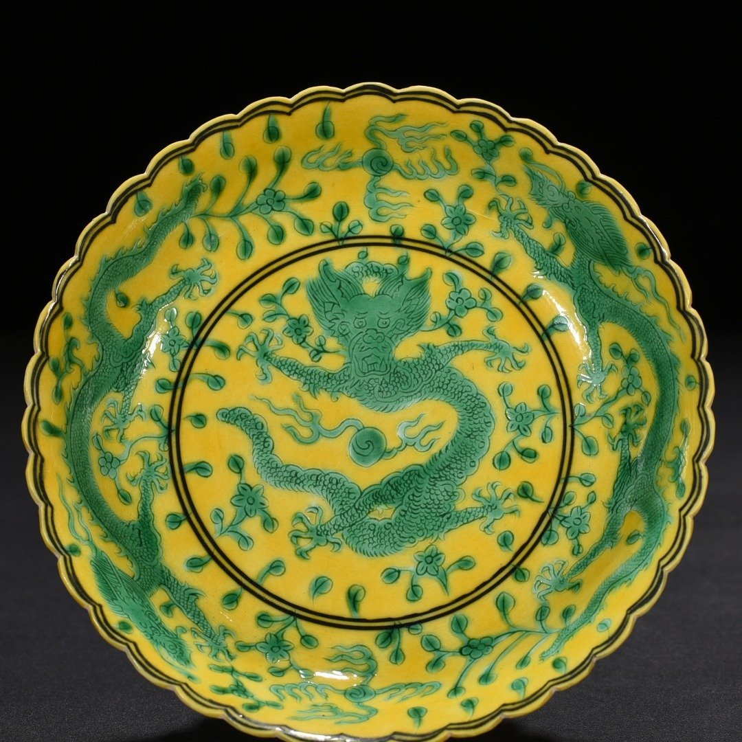 Qing Dynasty Qianlong plain three-color yellow ground engraved five-dragon sunflower mouth plate