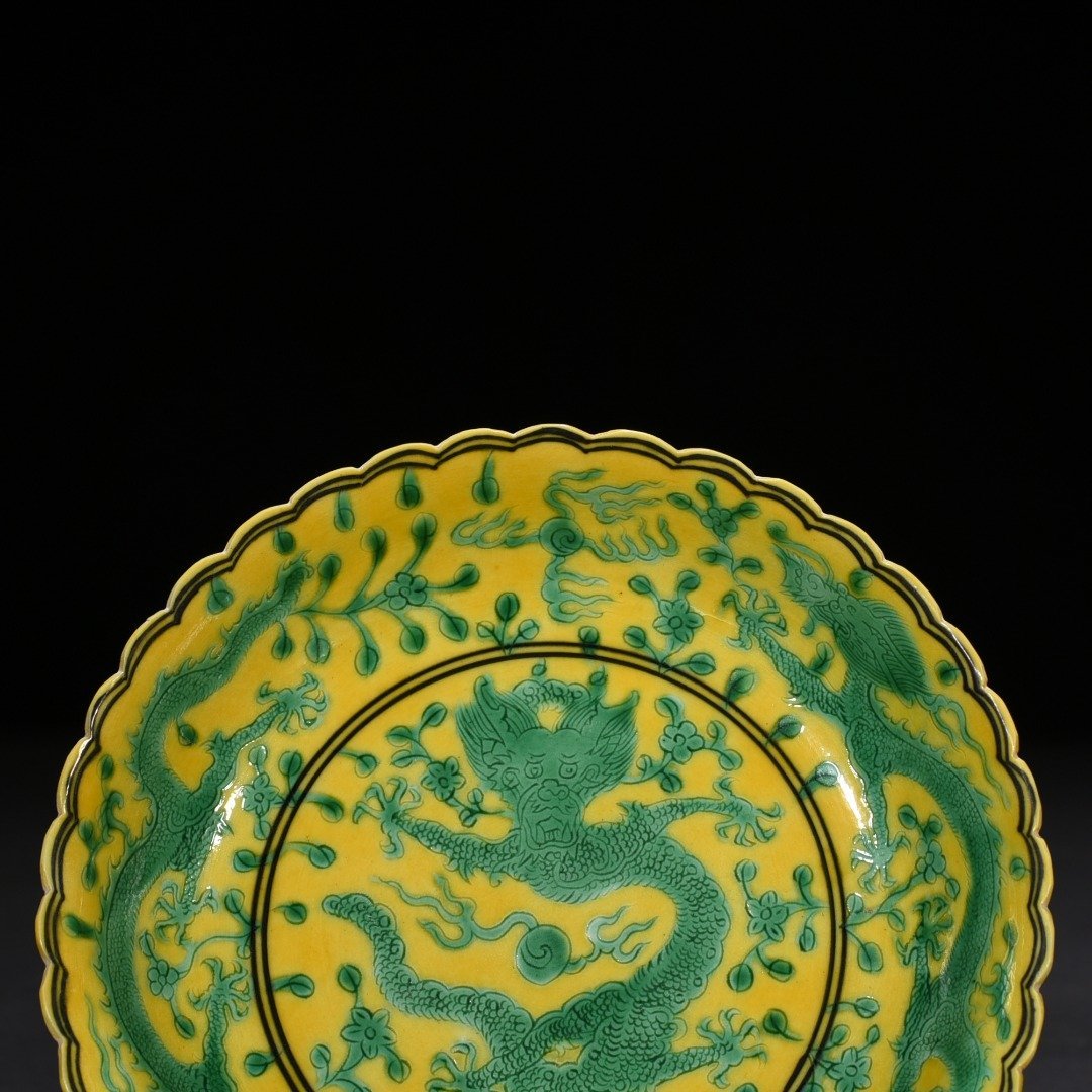 Qing Dynasty Qianlong plain three-color yellow ground engraved five-dragon sunflower mouth plate