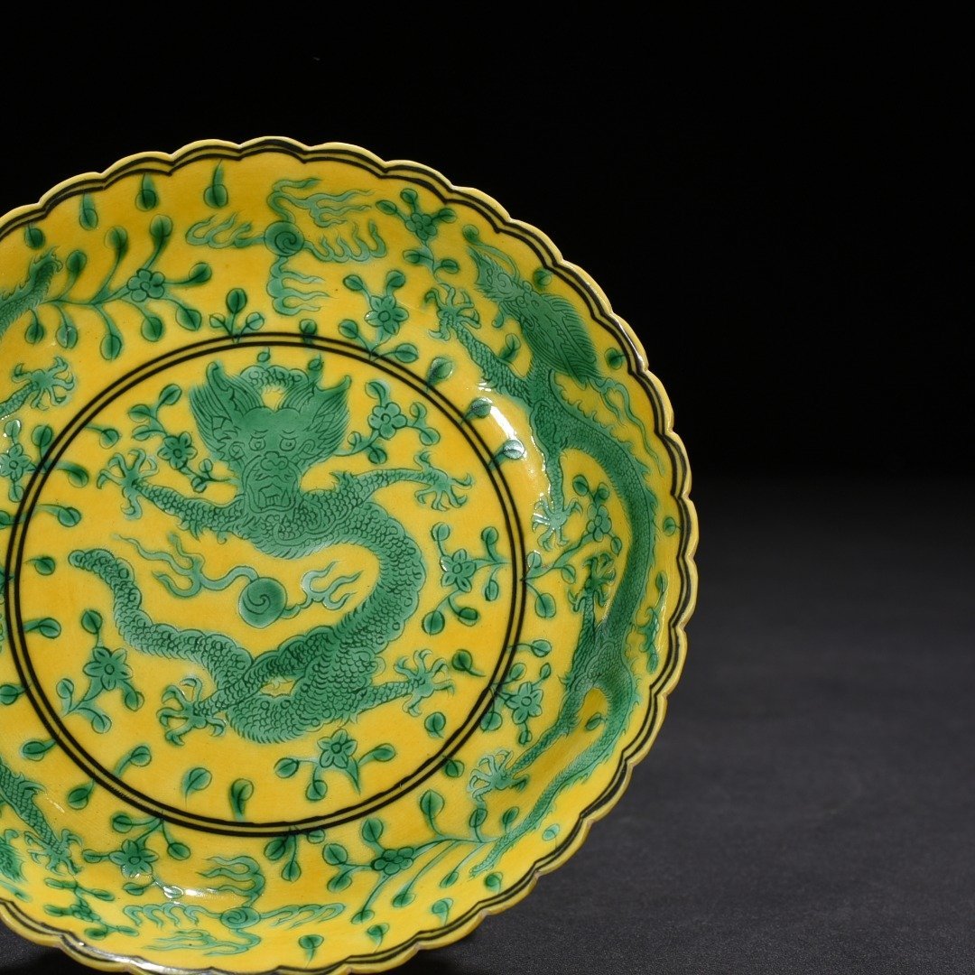 Qing Dynasty Qianlong plain three-color yellow ground engraved five-dragon sunflower mouth plate